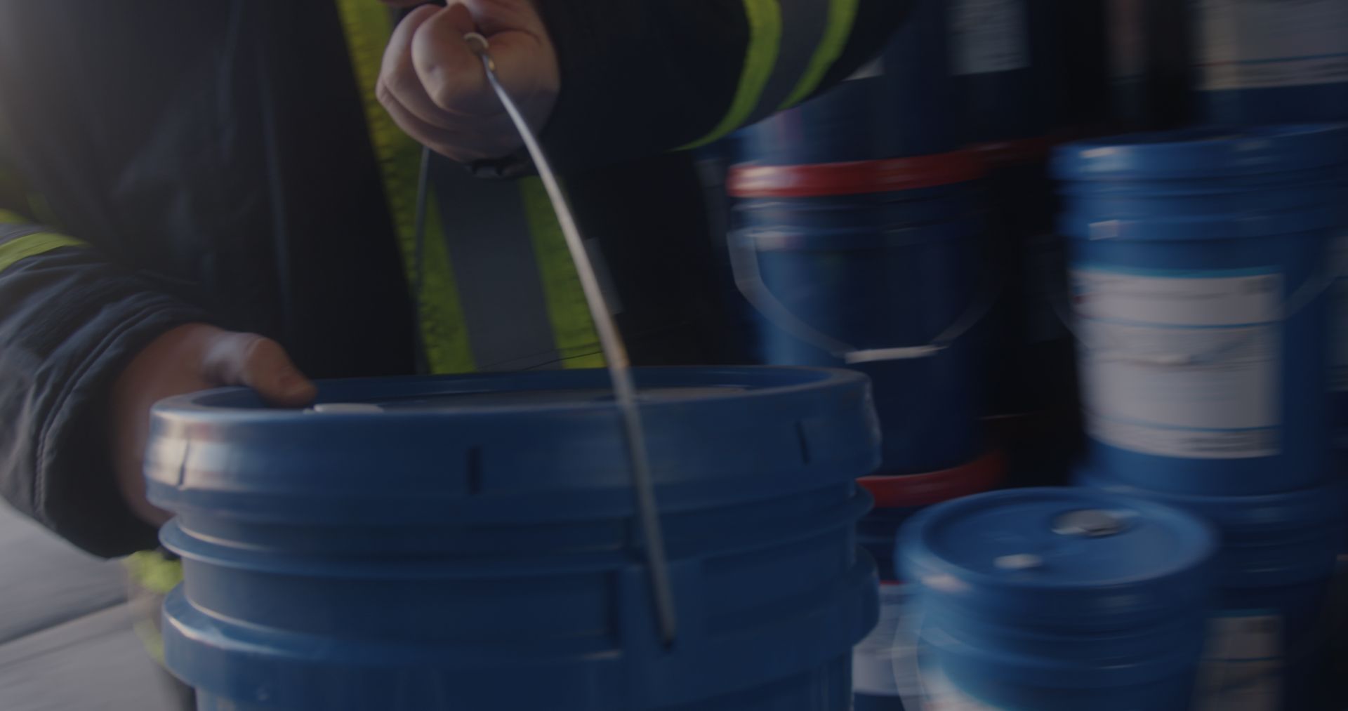 A man is holding a bucket with a spoon in it.