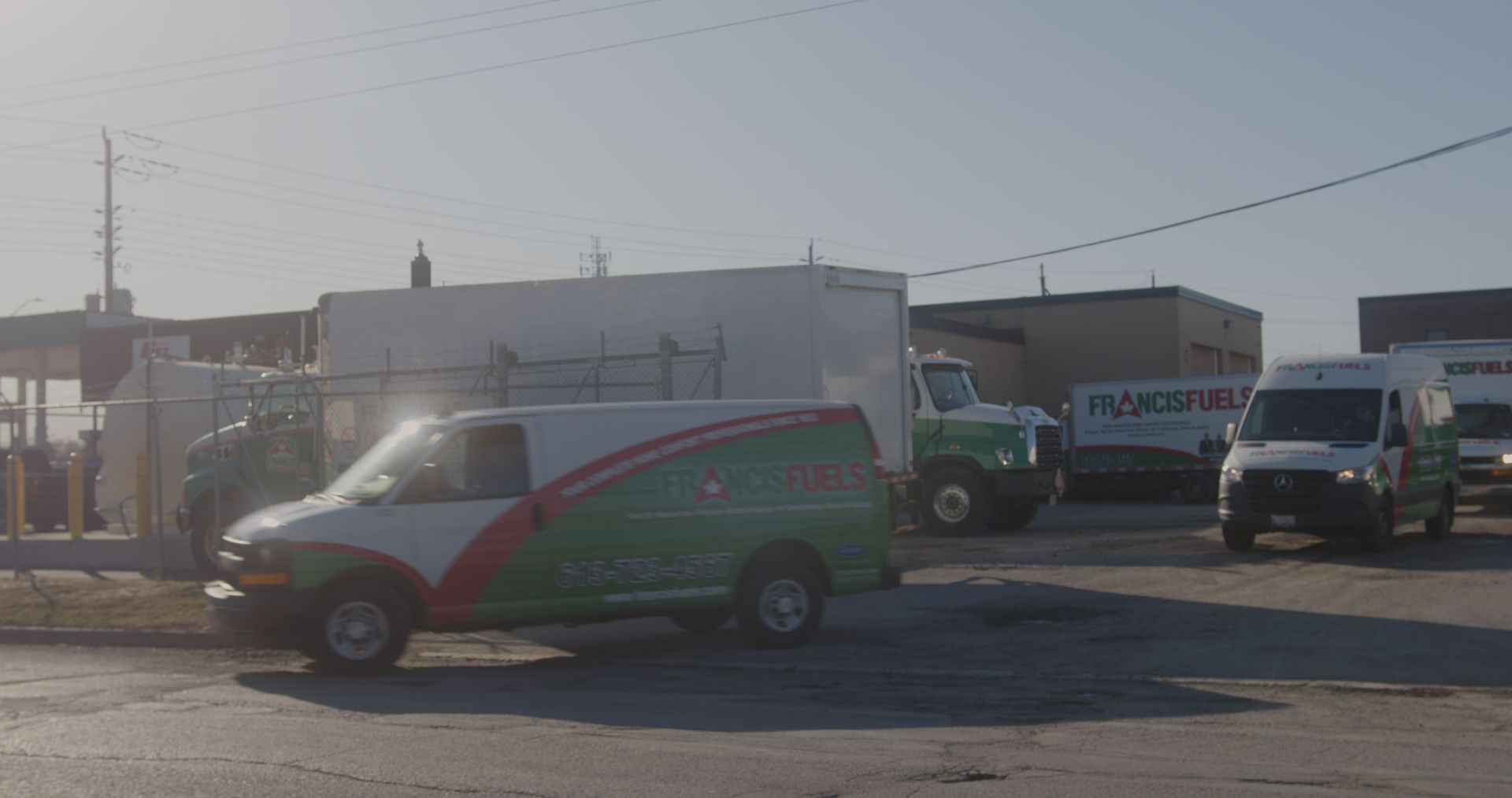 A green and white van is parked in a parking lot.
