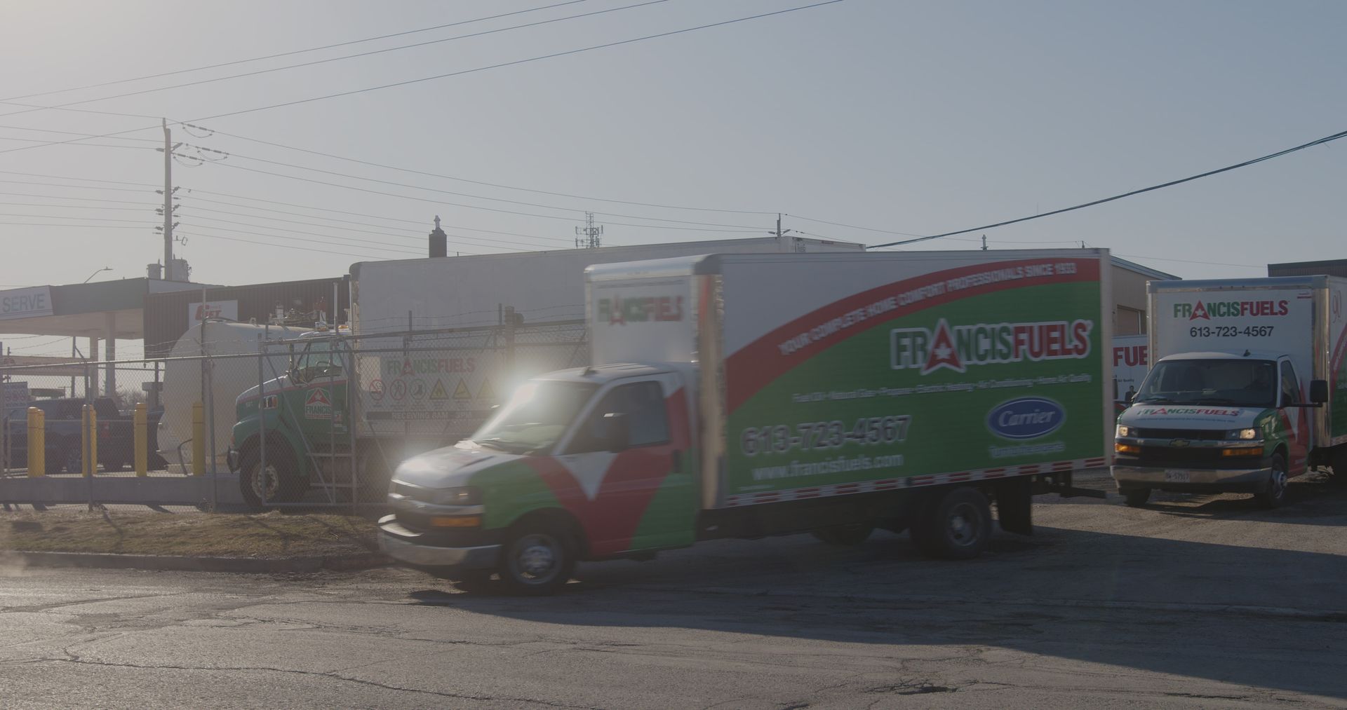A green and white truck is parked in a parking lot.