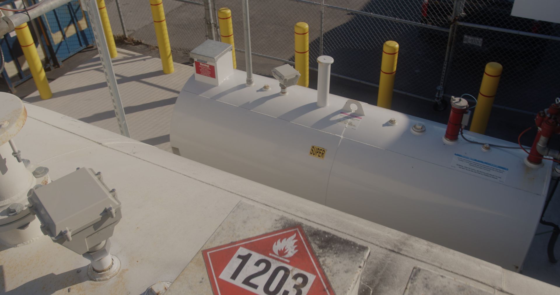 A large white tank with a red sign that says 1203 on it.