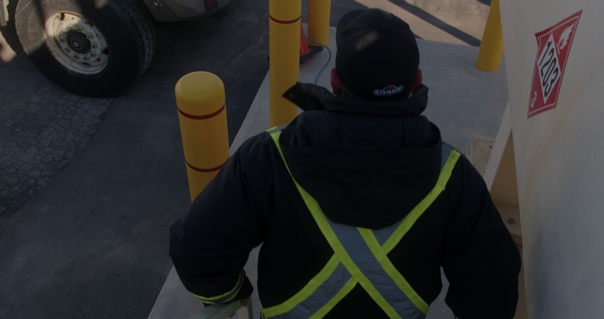 A man wearing a safety vest is walking down a set of stairs.