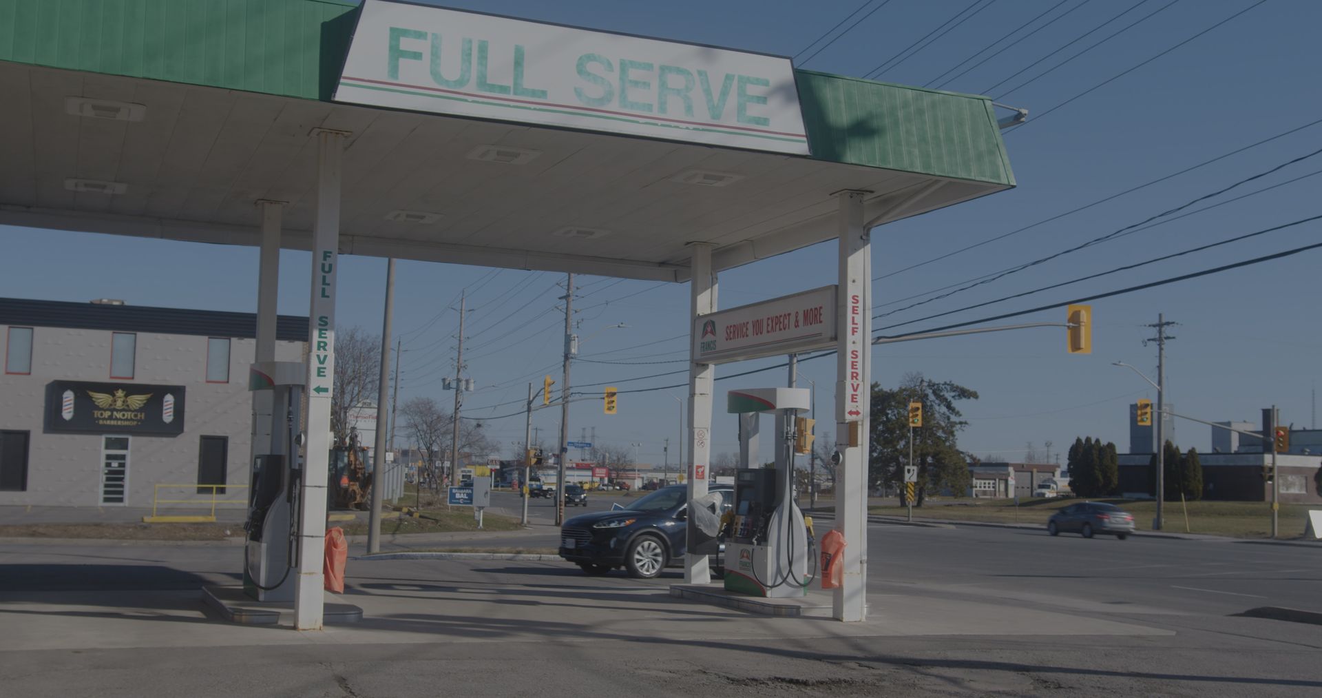 A gas station with a car parked in front of it.
