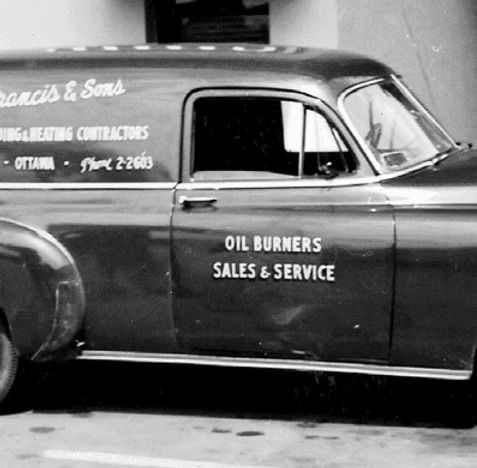 A black and white photo of an oil burners sales and service van