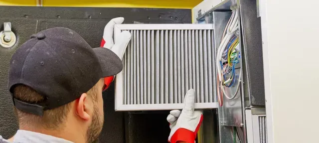 A man in a hat and gloves is holding a filter.