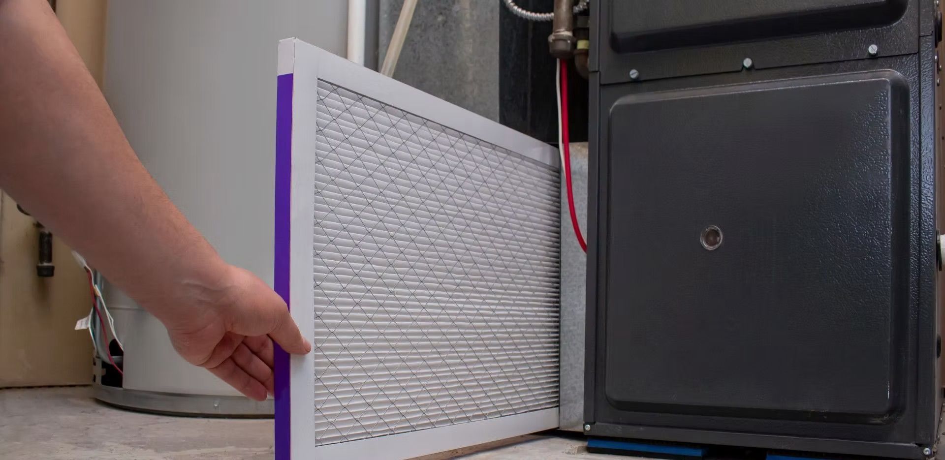 A person is changing a filter on a furnace.