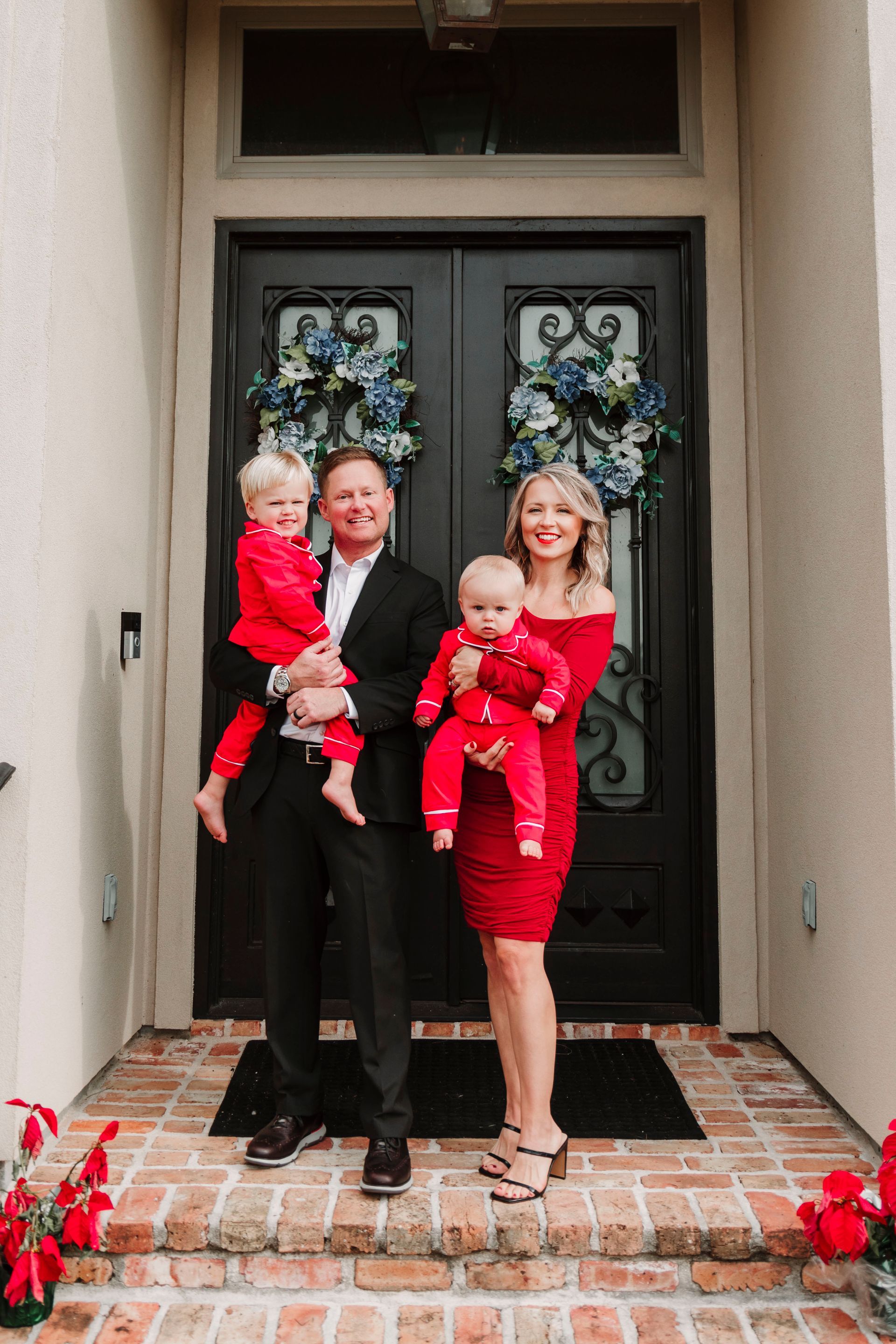 A family is posing for a picture in front of their house.