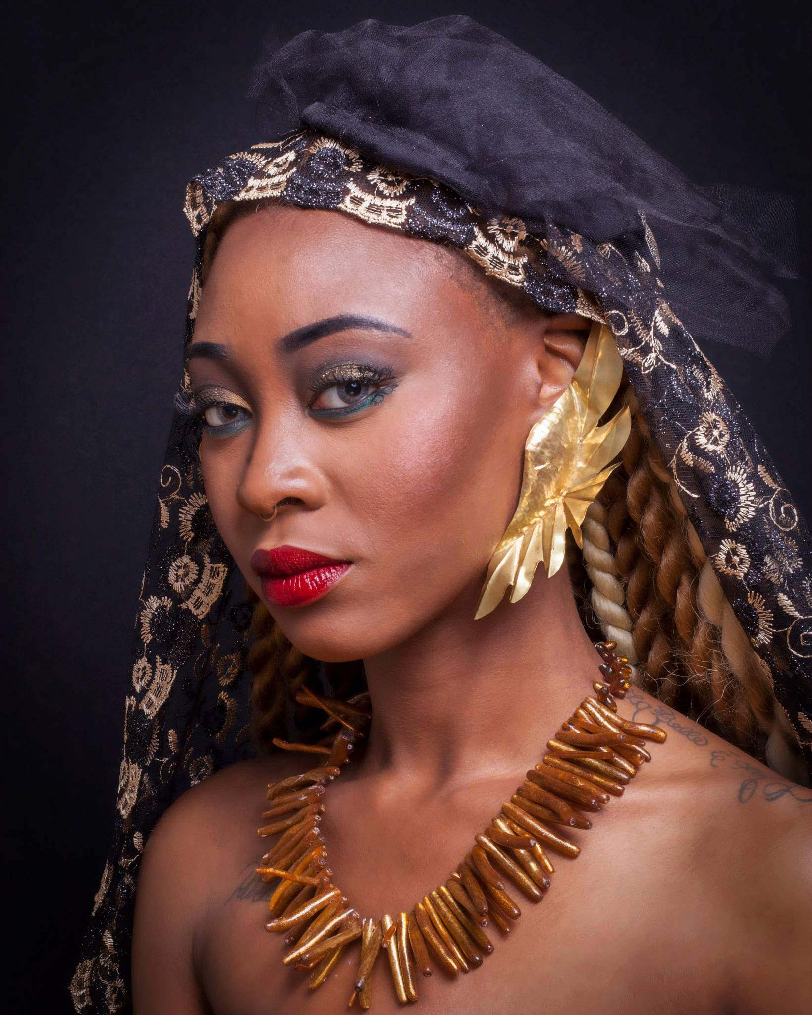 A woman wearing a black hat and a gold necklace