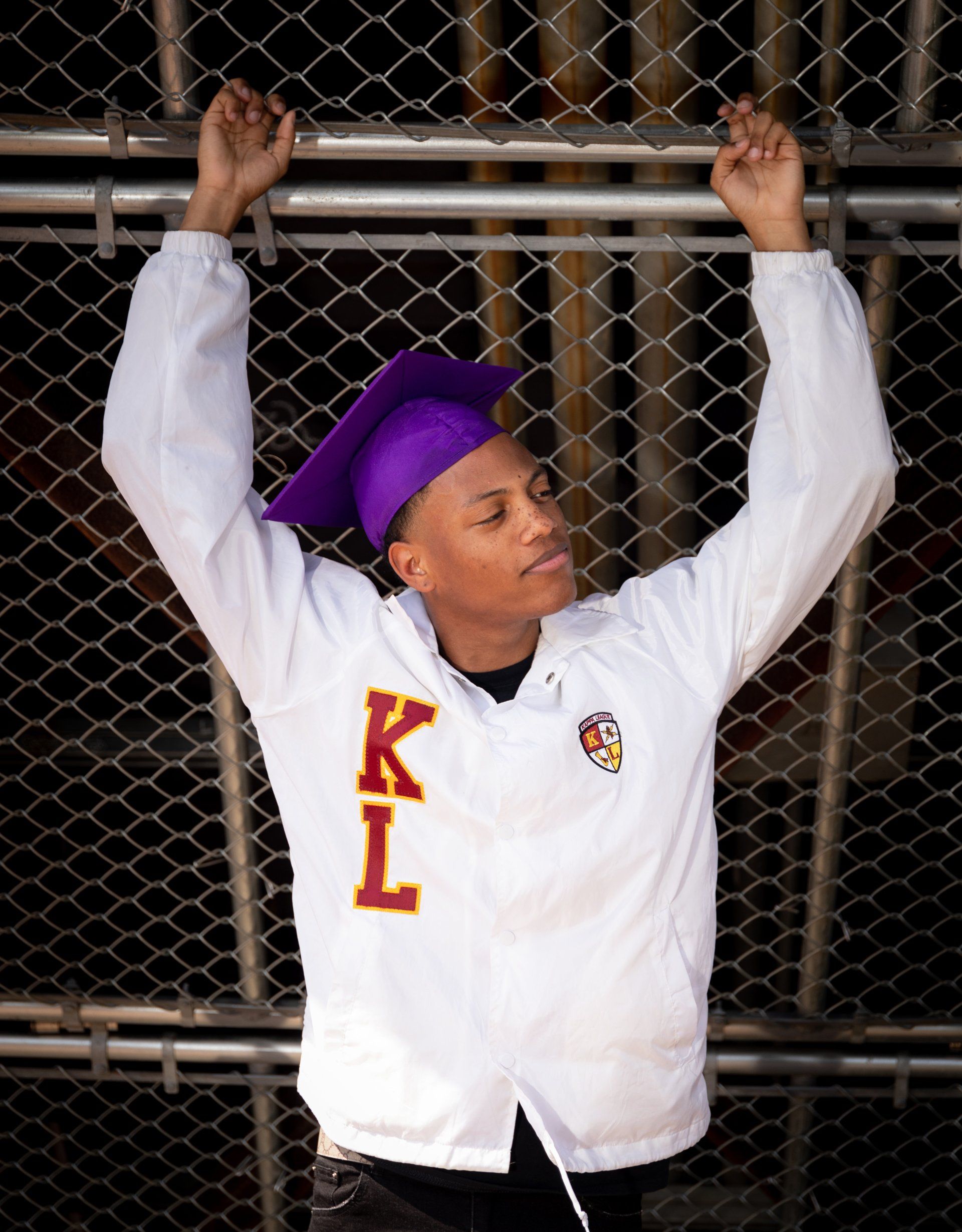 A man wearing a white jacket with the letter k on it