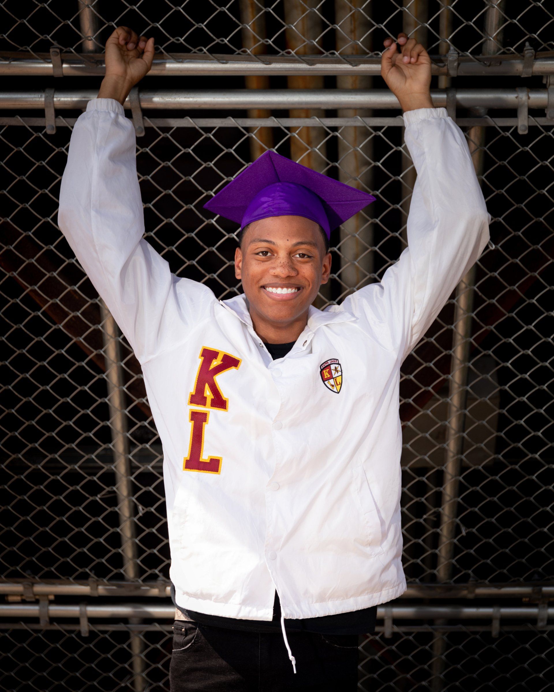 A man wearing a white jacket with the letter k on it