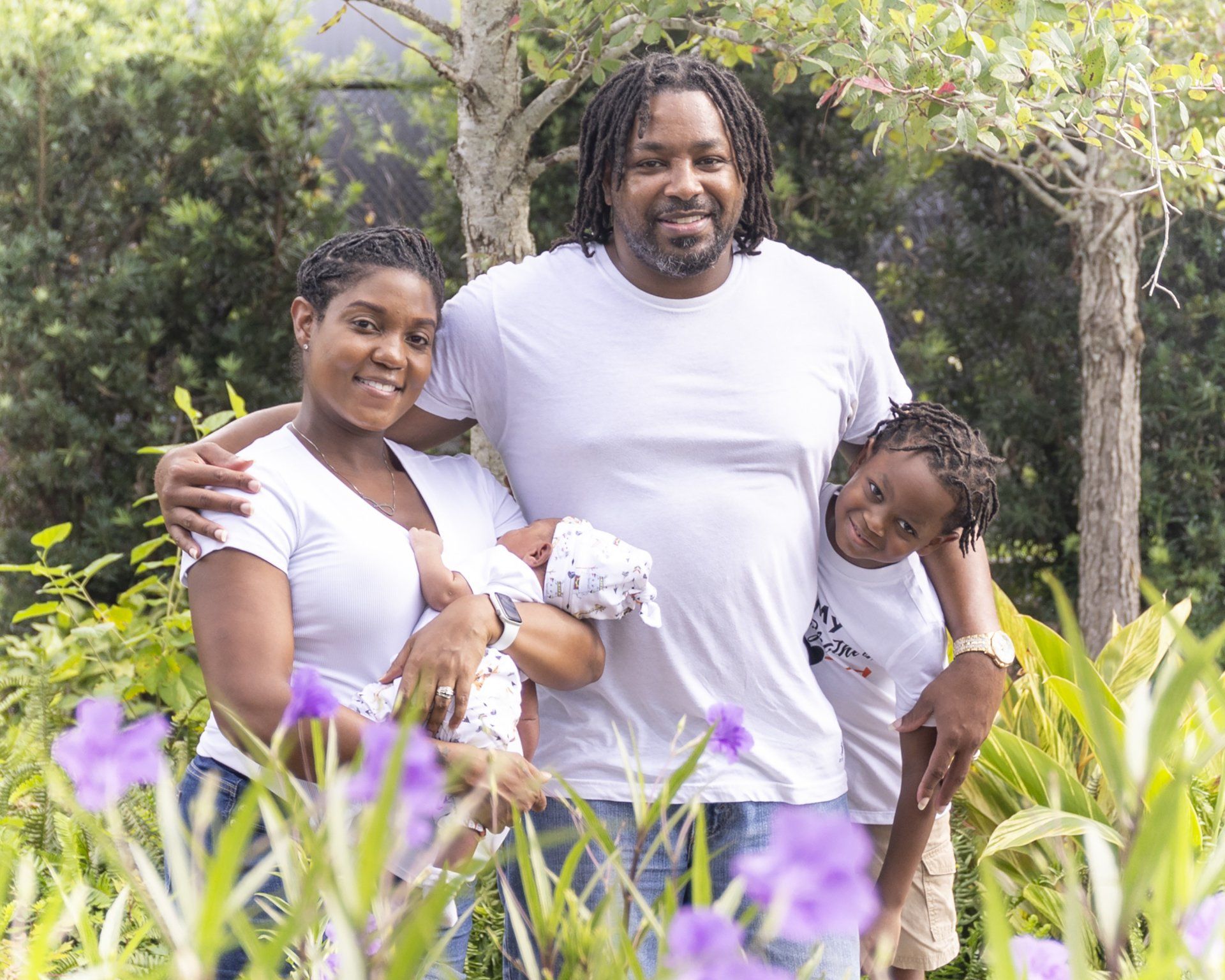 A family is posing for a picture in a field of purple flowers.