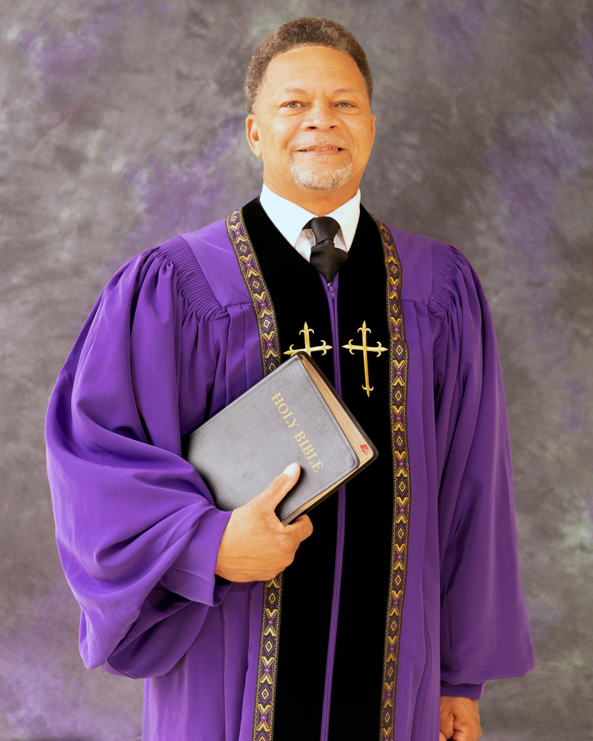A man in a purple robe is holding a bible