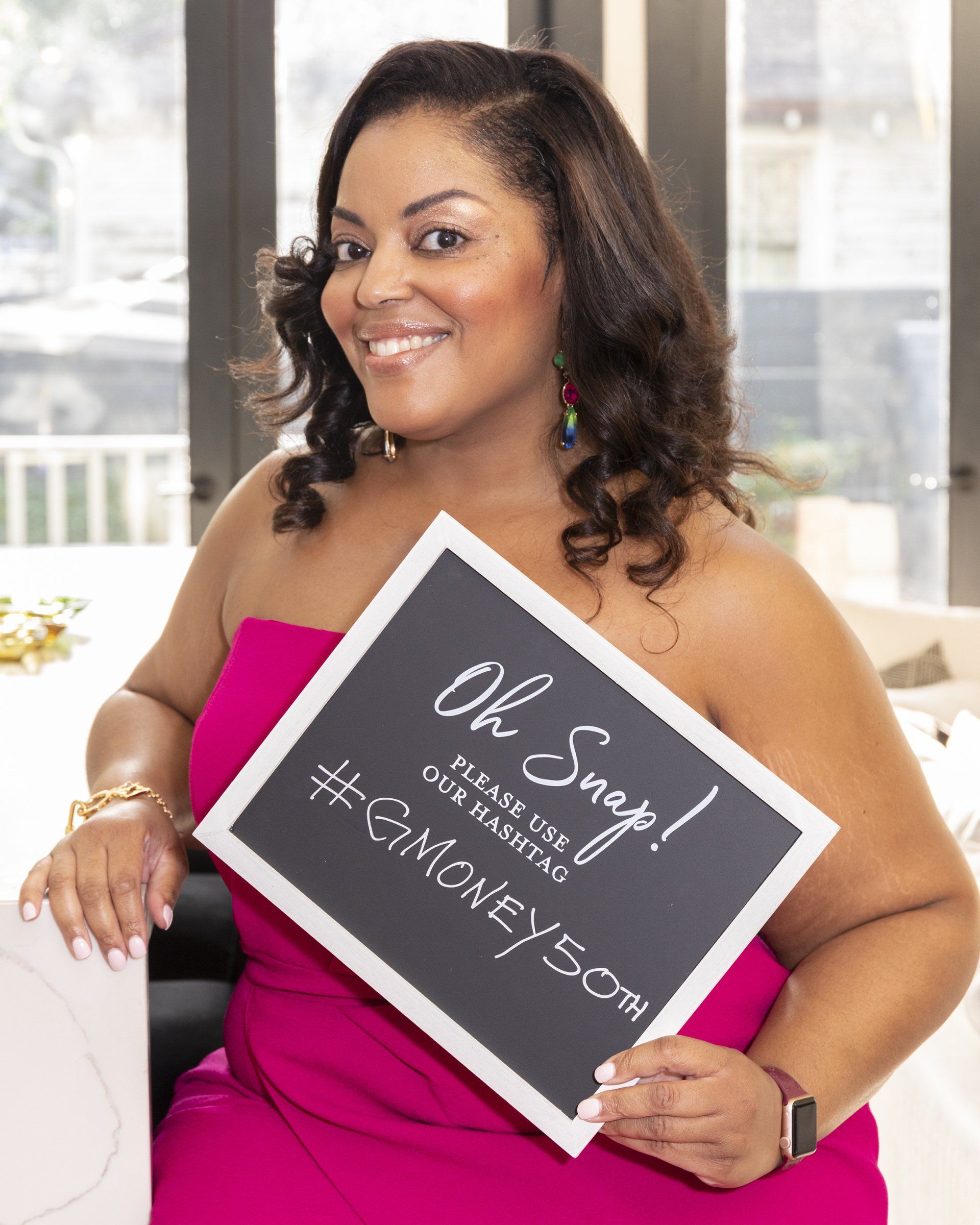 A woman in a pink dress is holding a sign that says oh snap !