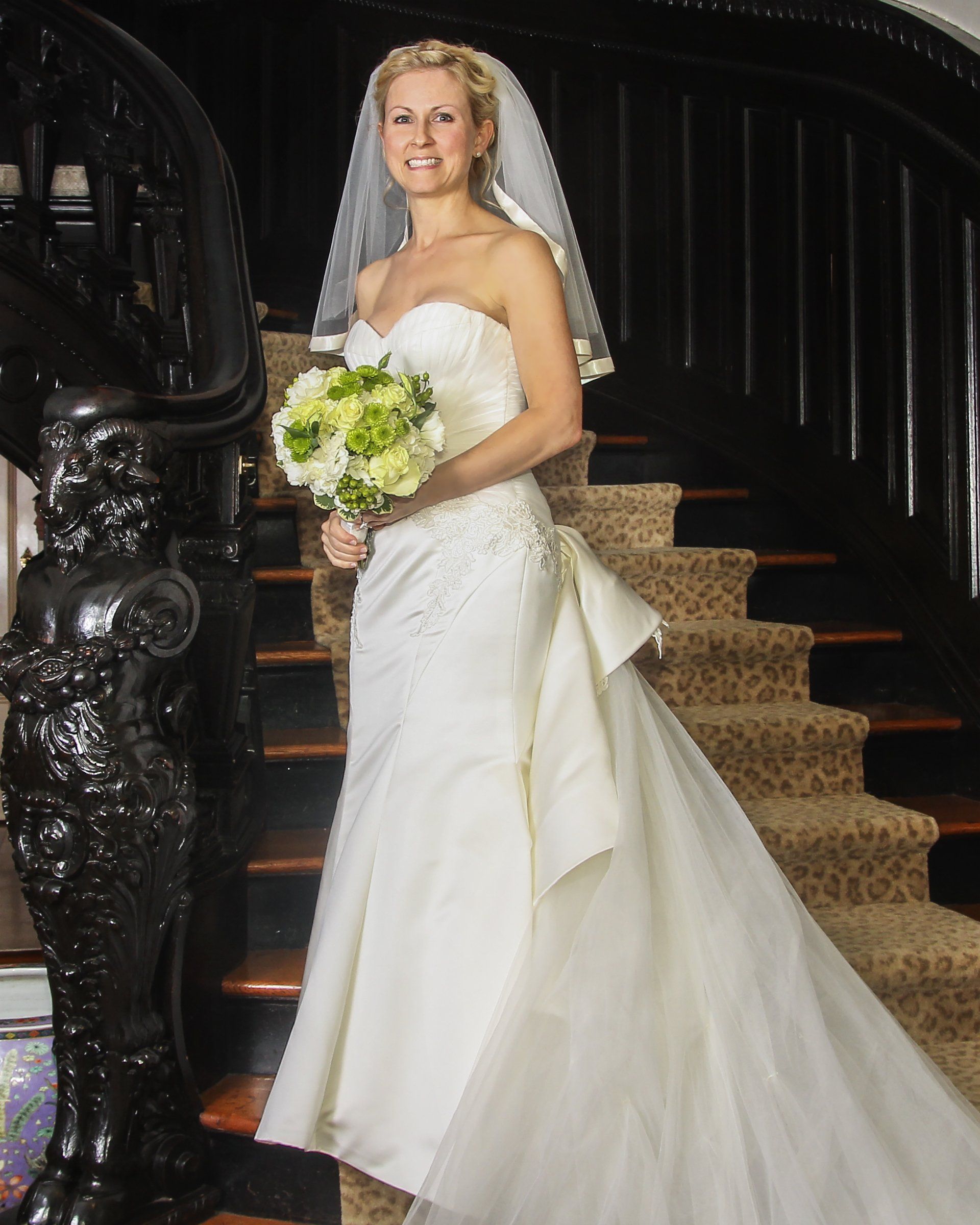 A woman in a wedding dress is standing on a set of stairs