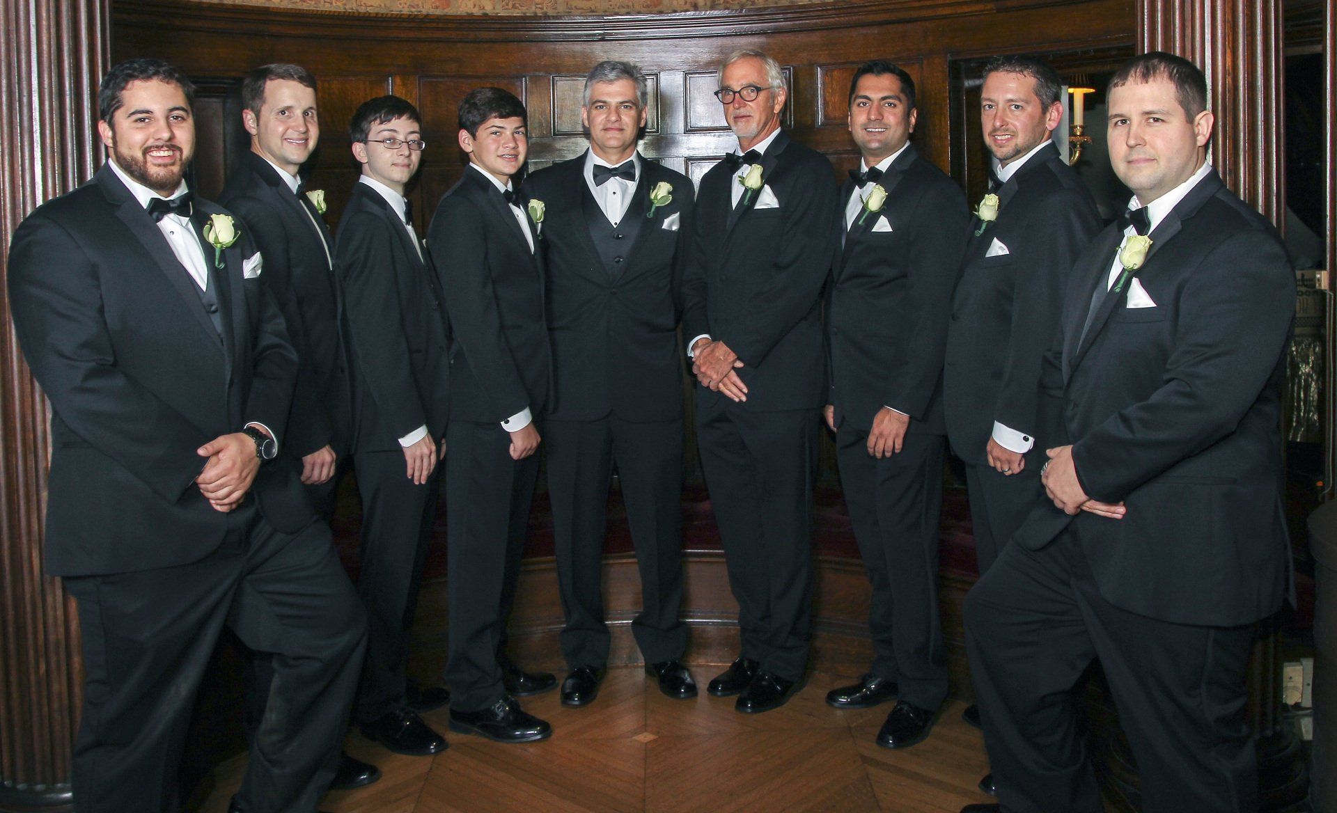 A group of men in tuxedos are posing for a picture