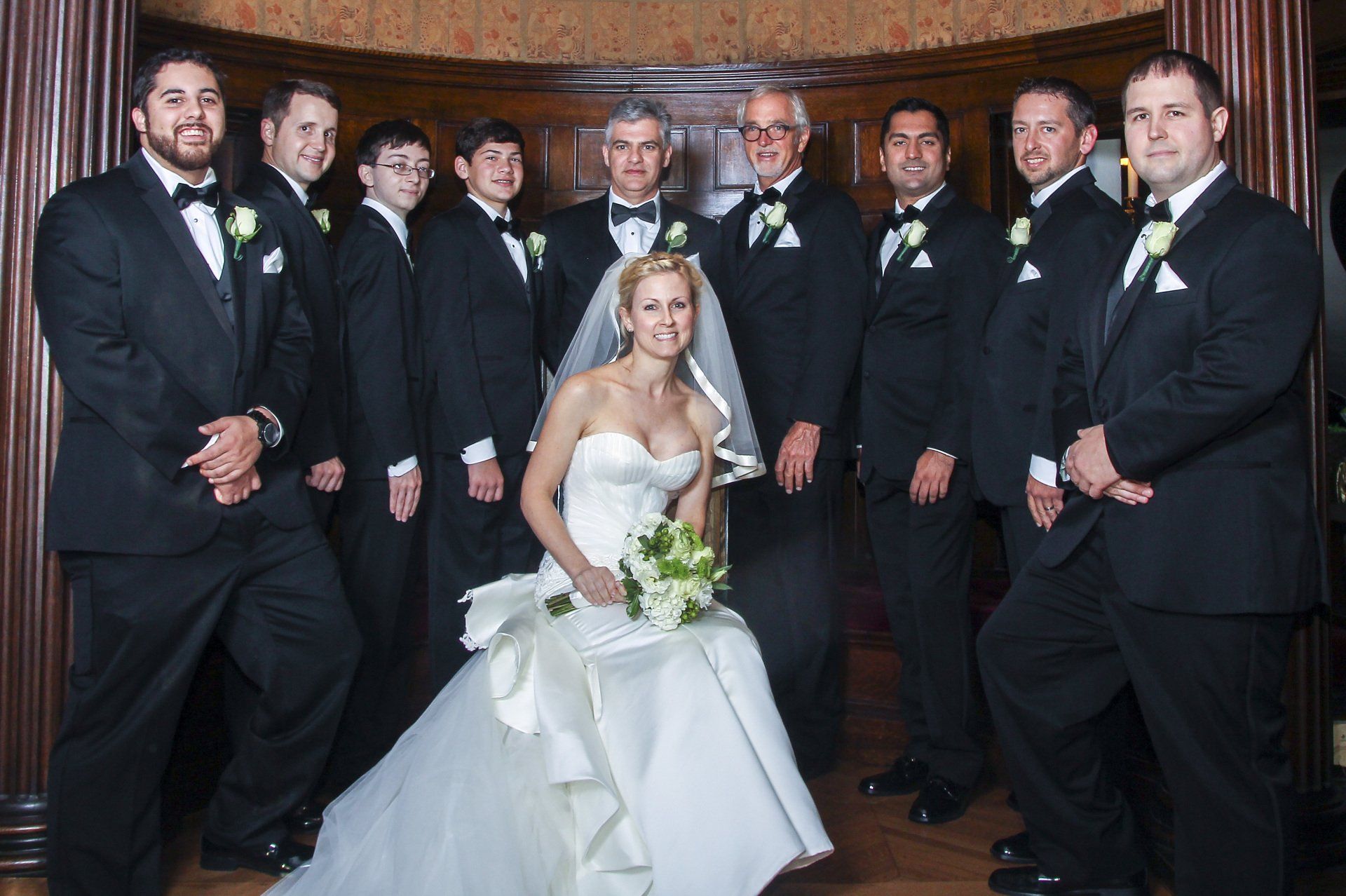 A bride and groom pose for a picture with their wedding party