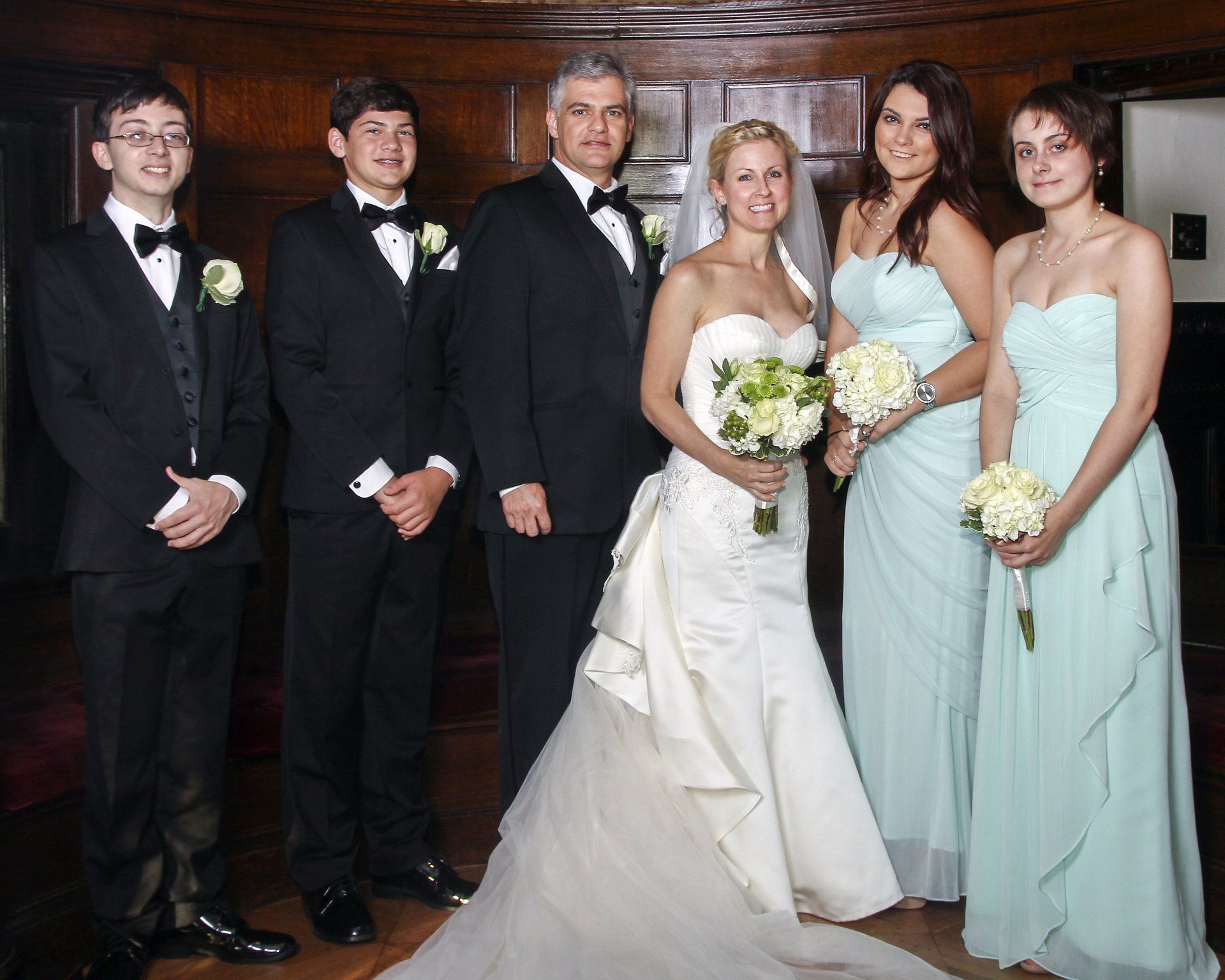 A bride and groom pose with their wedding party