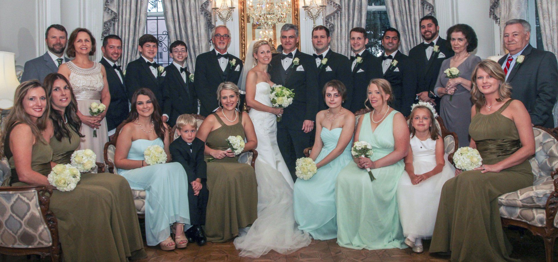 A large group of people are posing for a picture at a wedding.