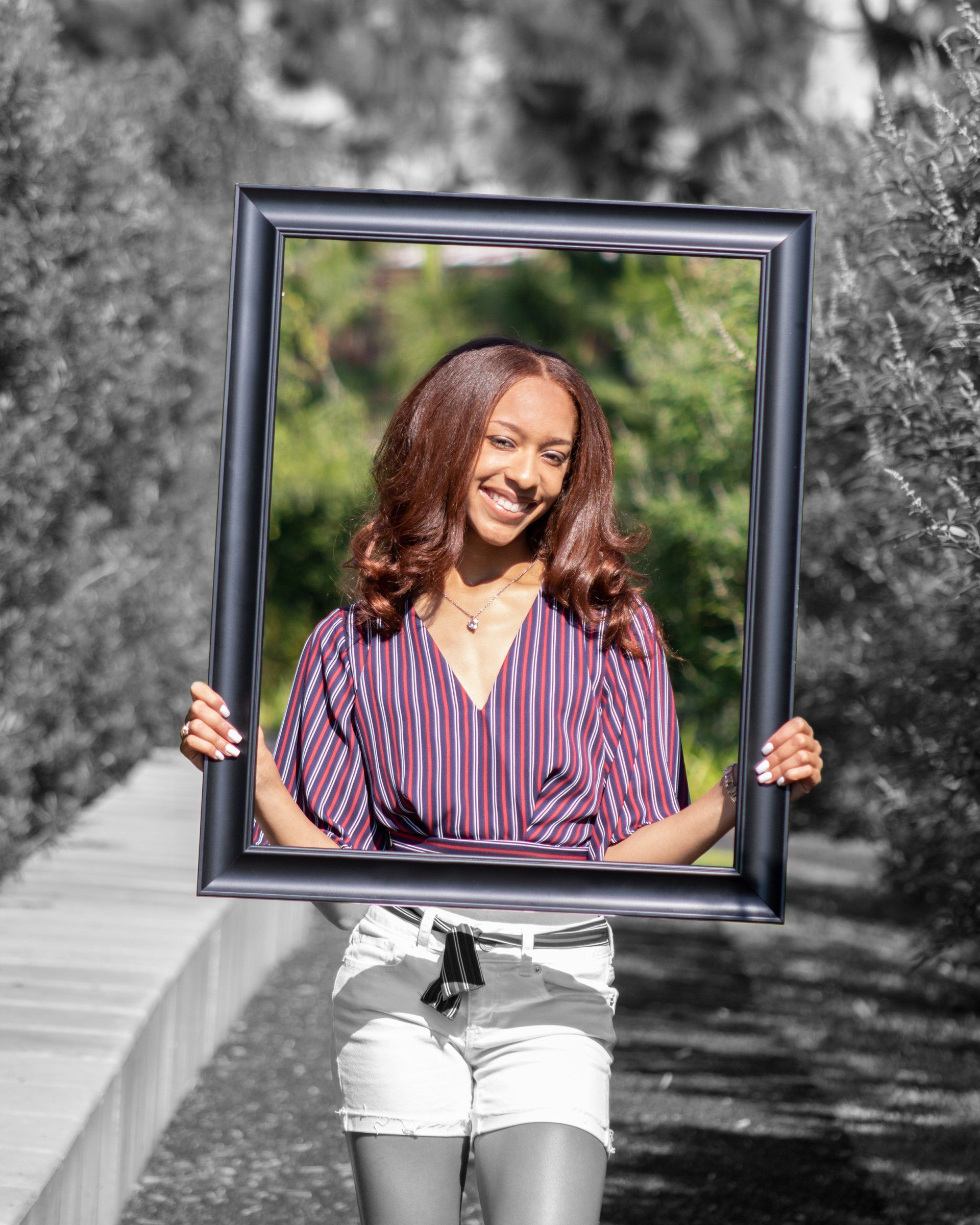 A woman is holding a picture frame over her head.