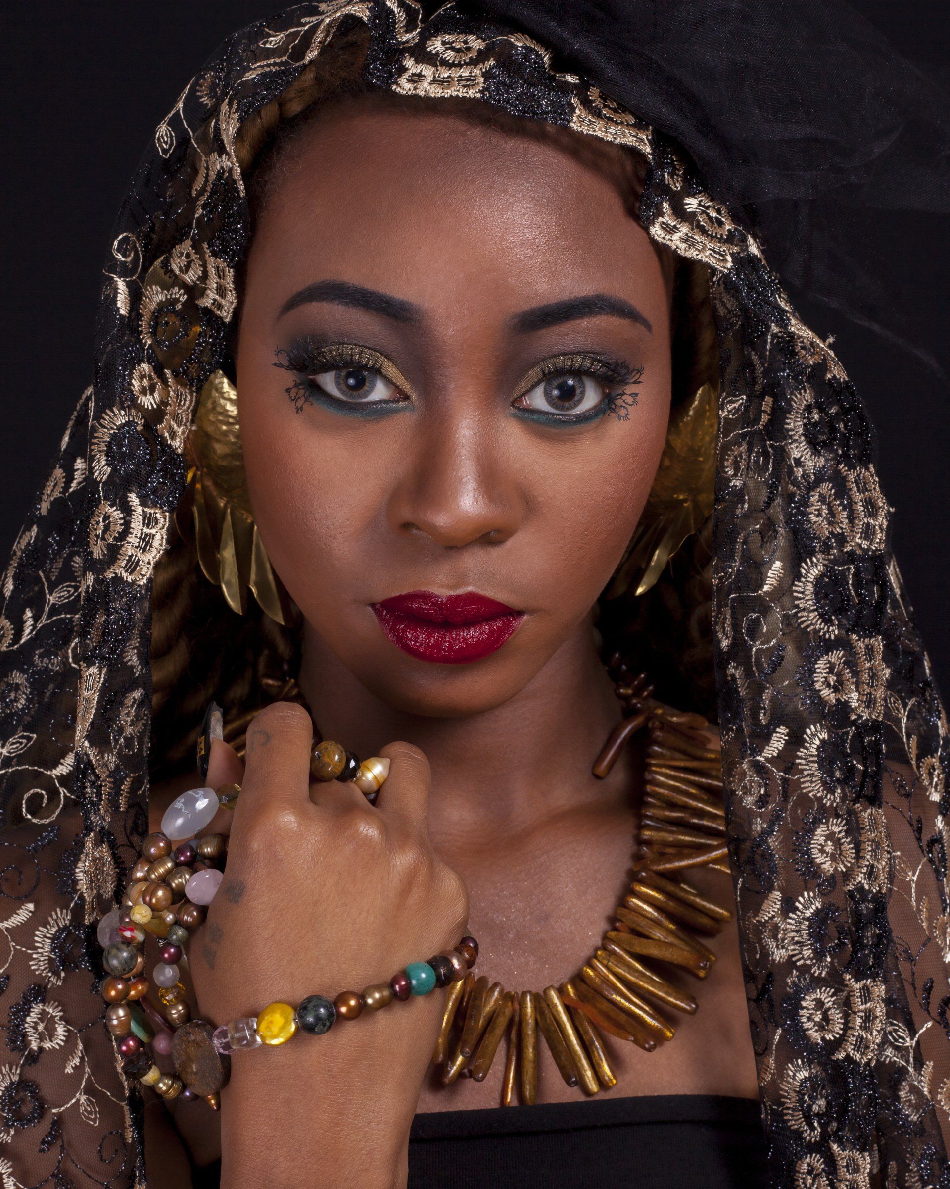 A woman wearing a black veil and gold jewelry