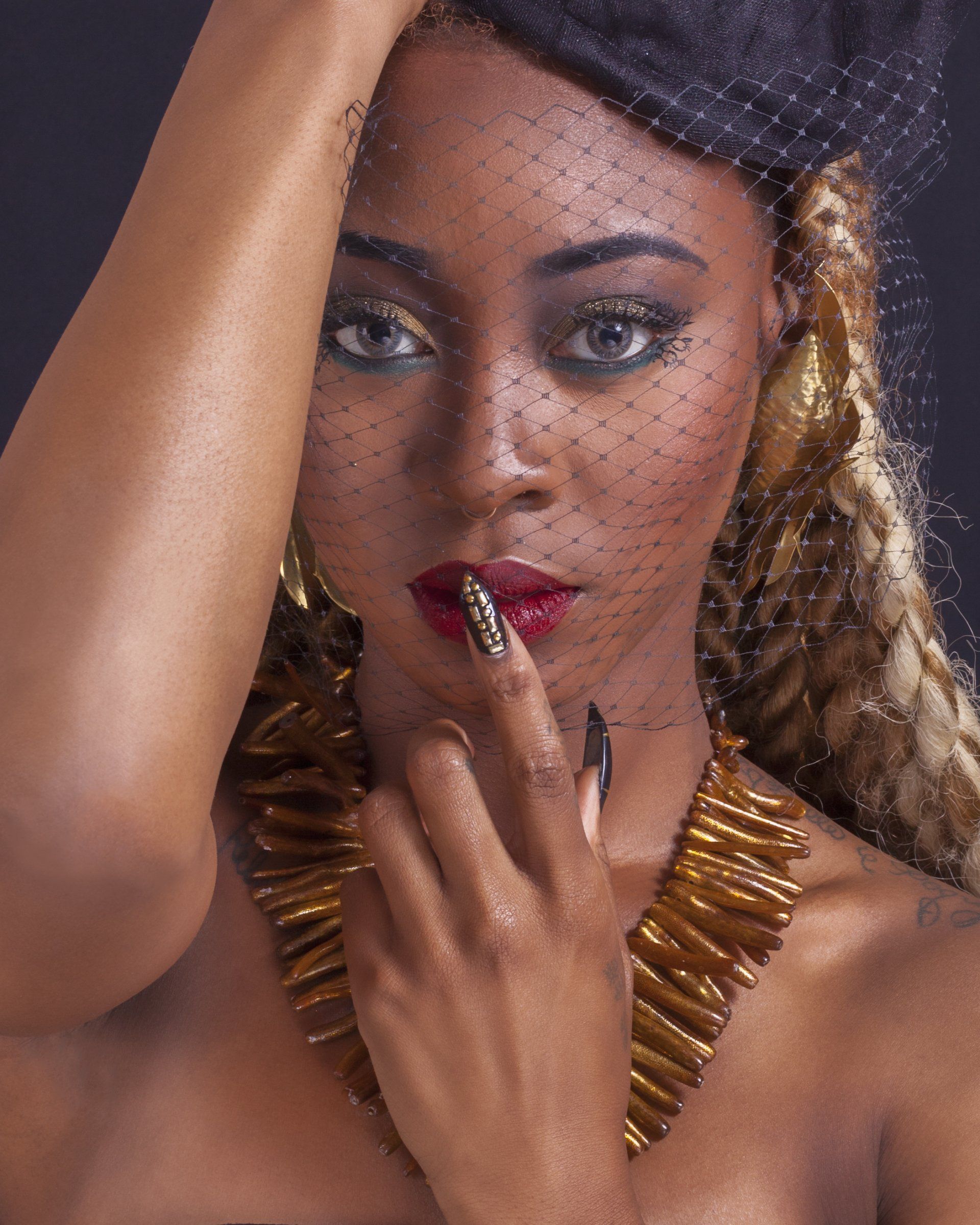 A woman wearing a black hat and a gold necklace