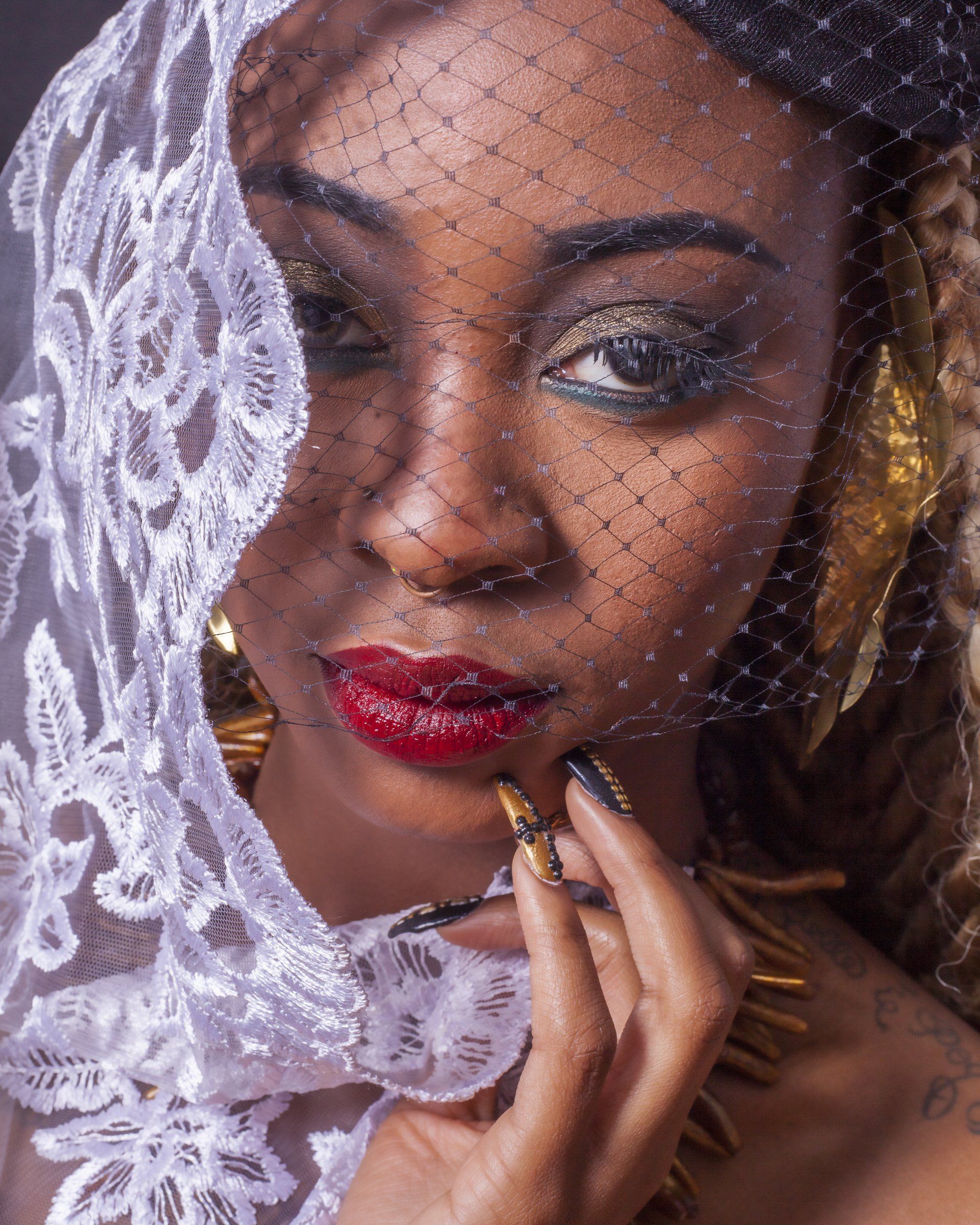 A woman wearing a lace veil covering half of her face