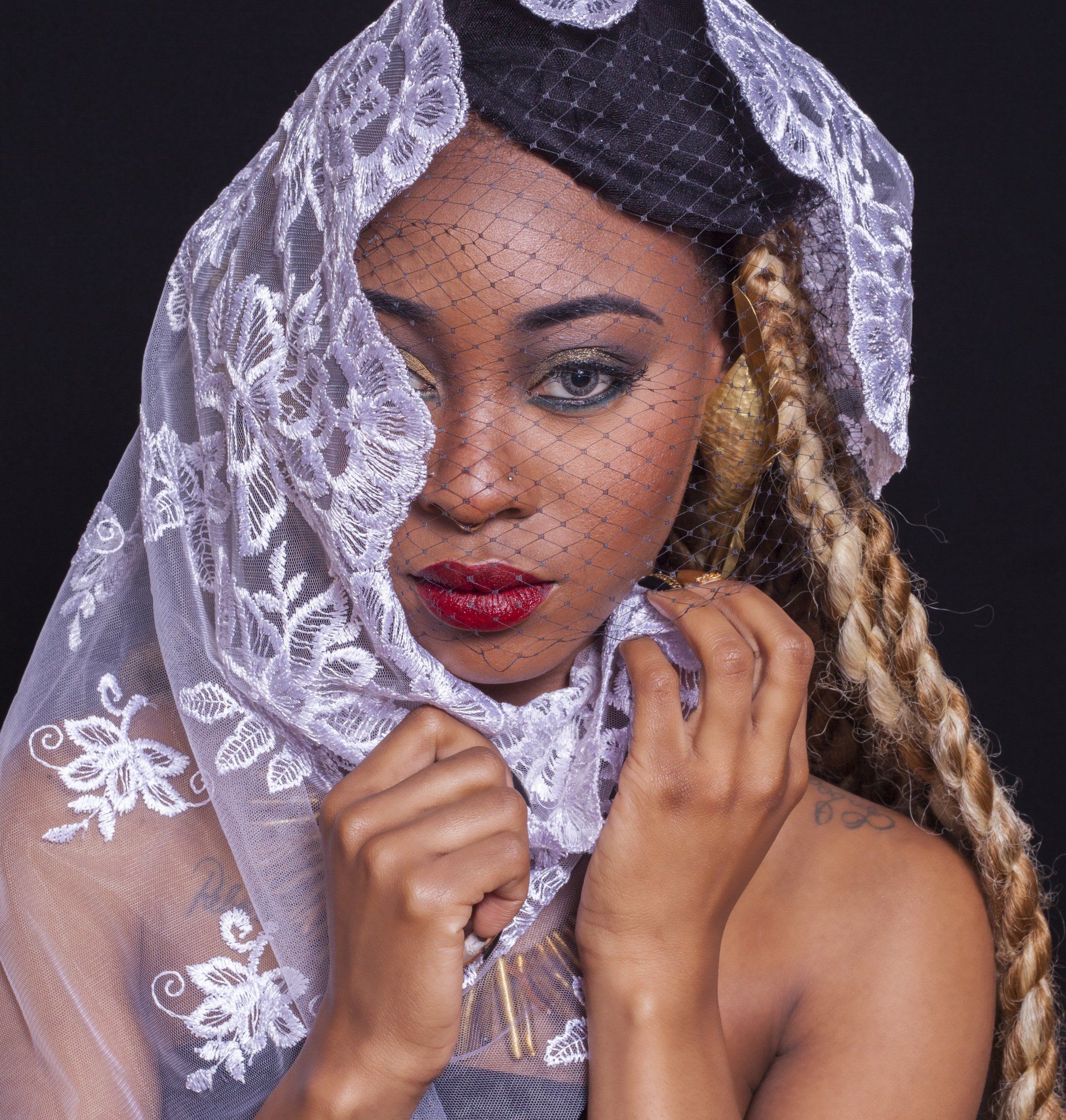 A woman covering her face with a white lace veil