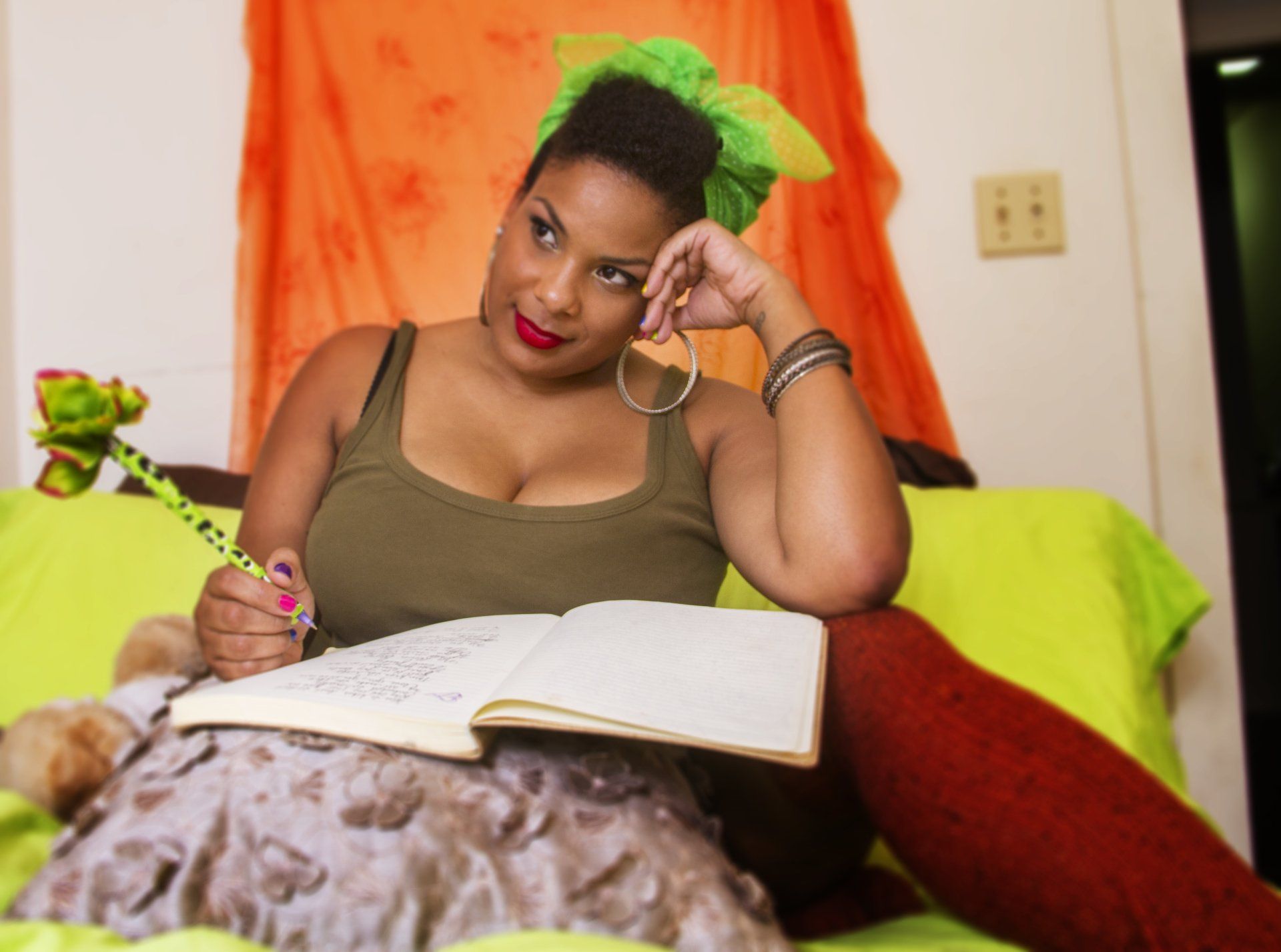 A woman is sitting on a couch writing in a notebook