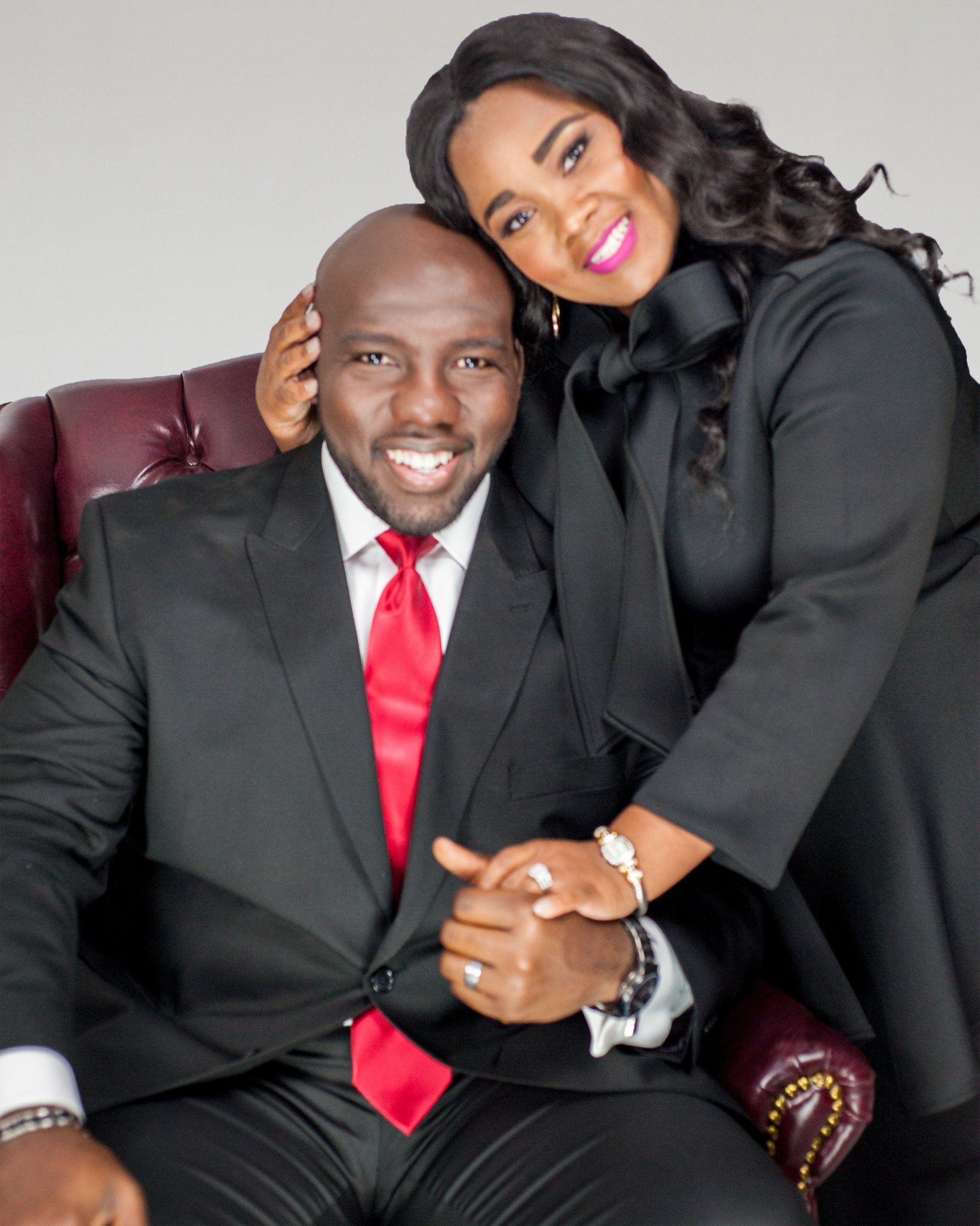 A man in a suit and tie is sitting next to a woman in a black dress