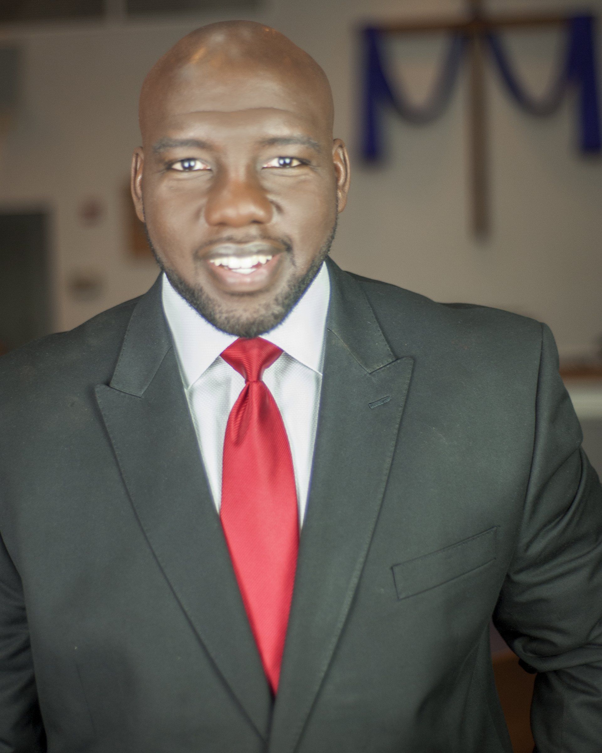 A man in a suit and tie is smiling for the camera.