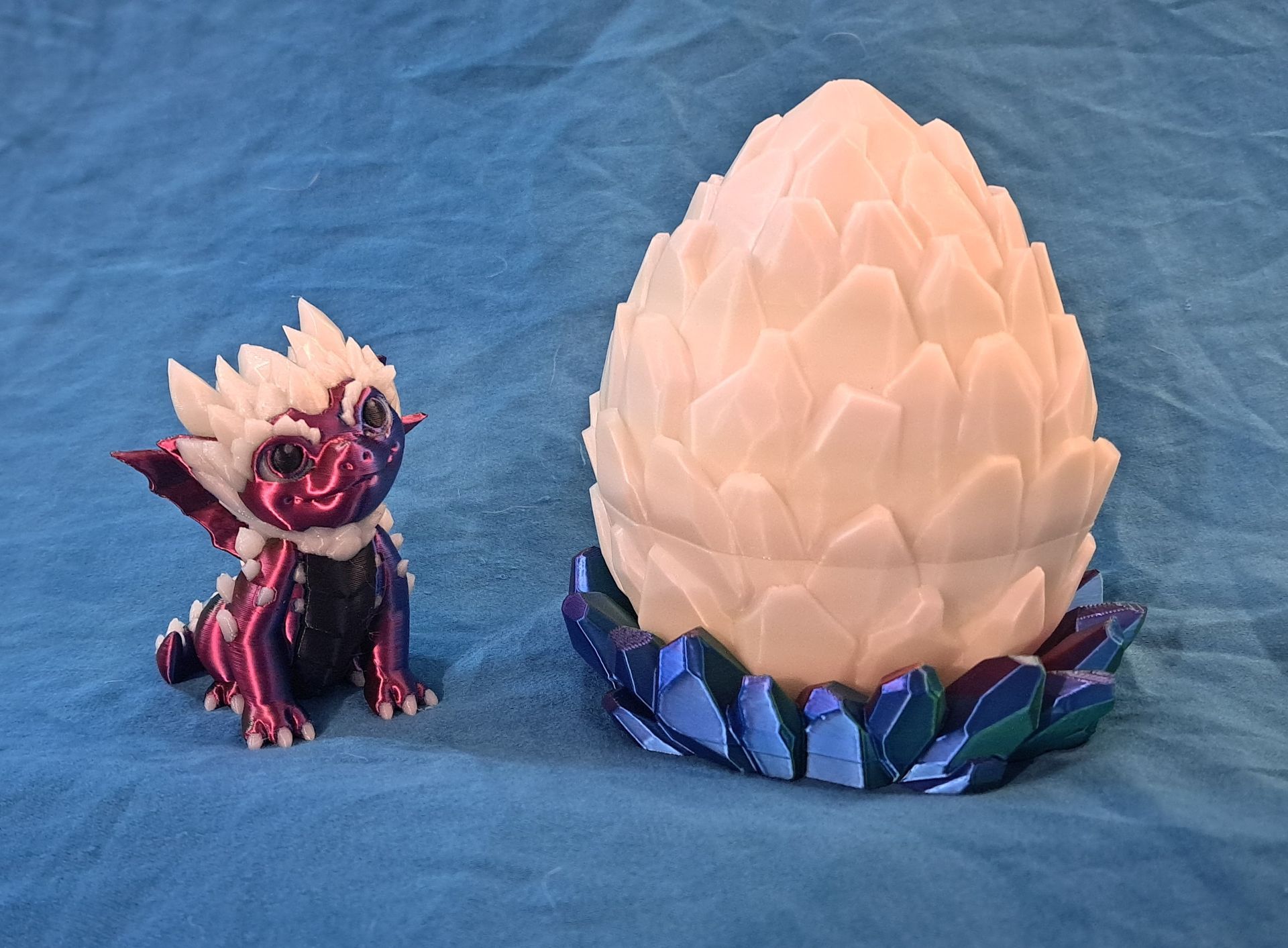 3D-printed dragon figurine with a crystal egg on a color changing, faceted base.