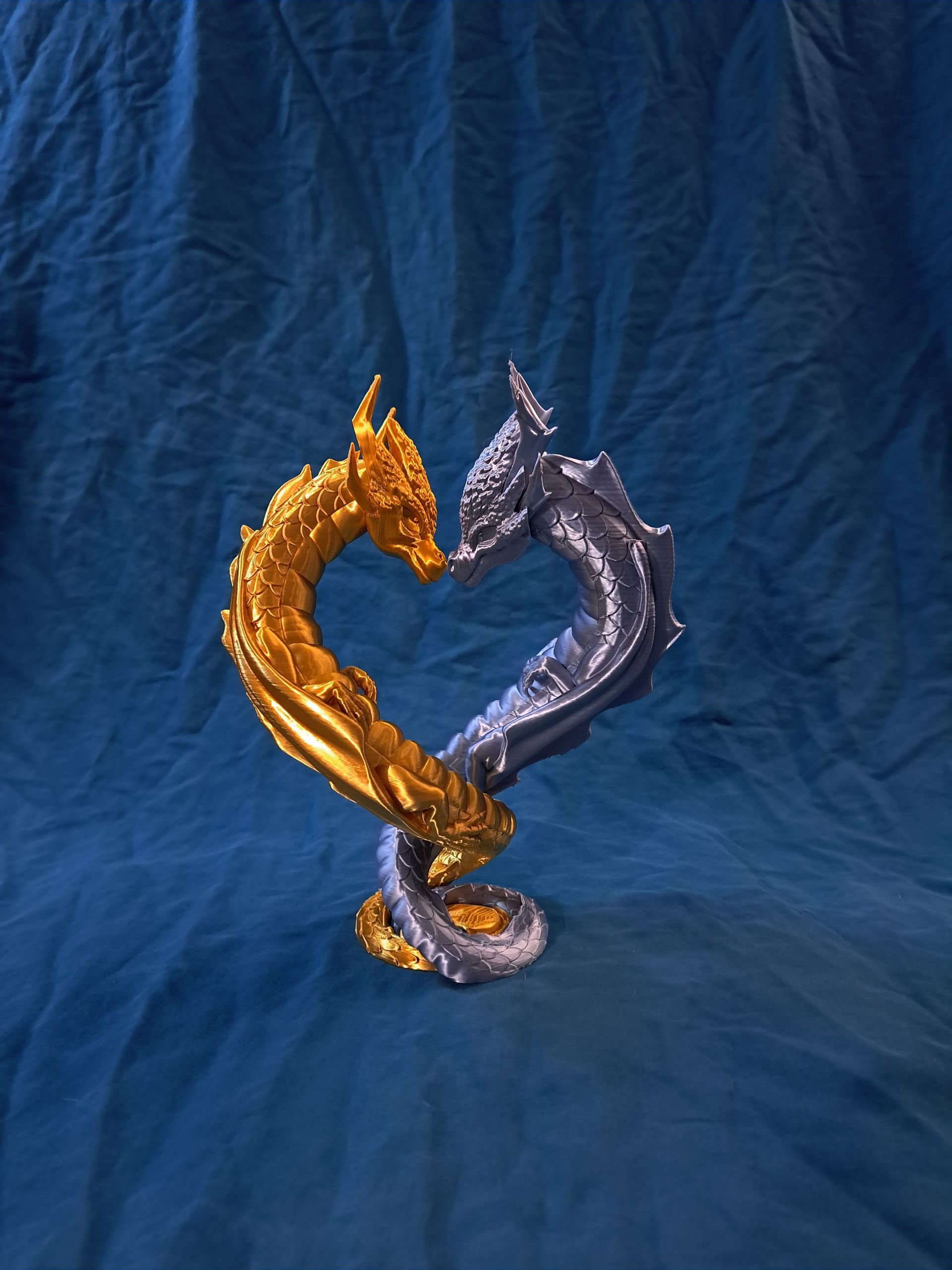 Intertwined gold and silver dragon sculpture  forming a heart shape.