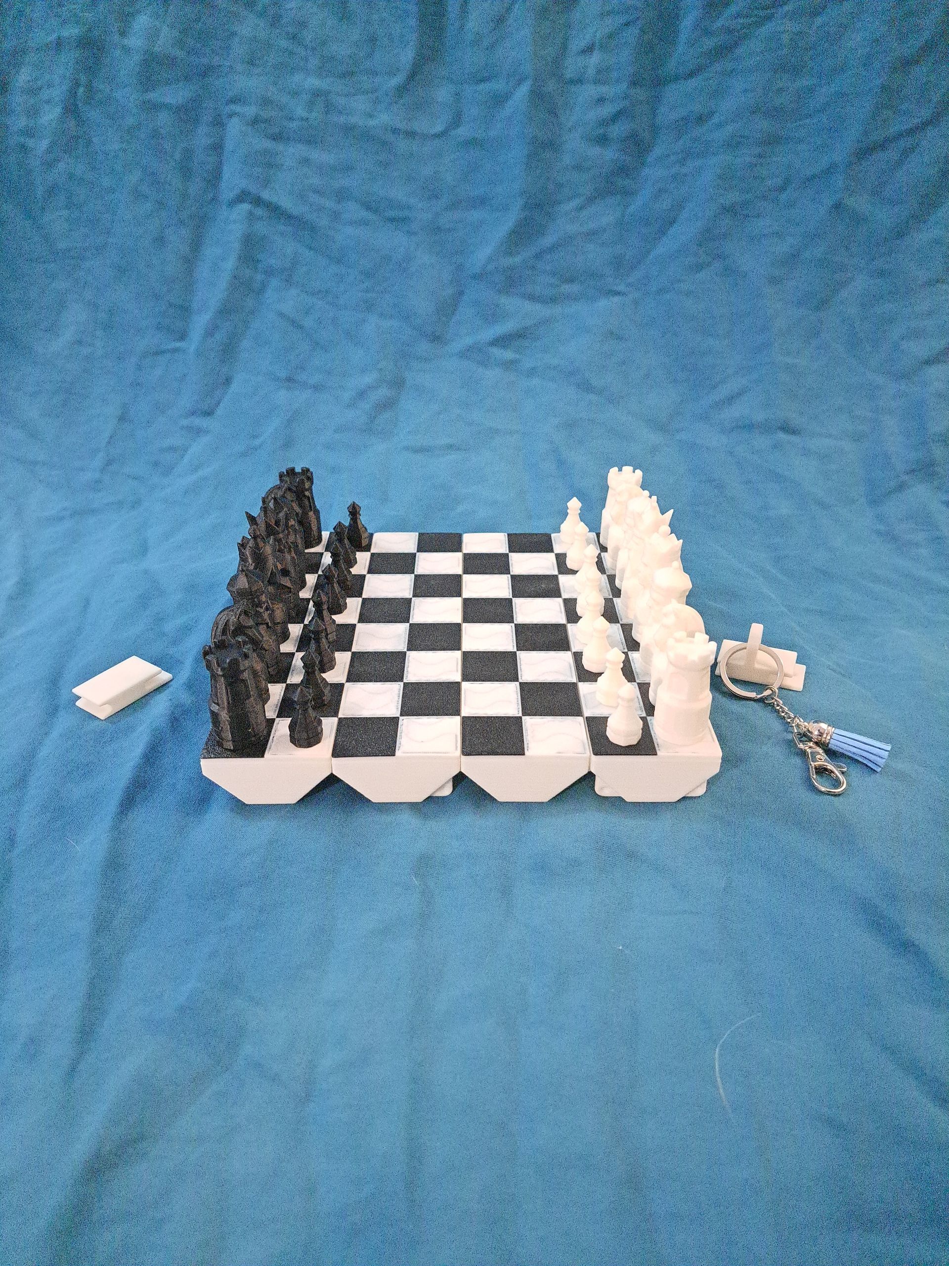 A 3D-printed chess set with black and white pieces on a checkered board.