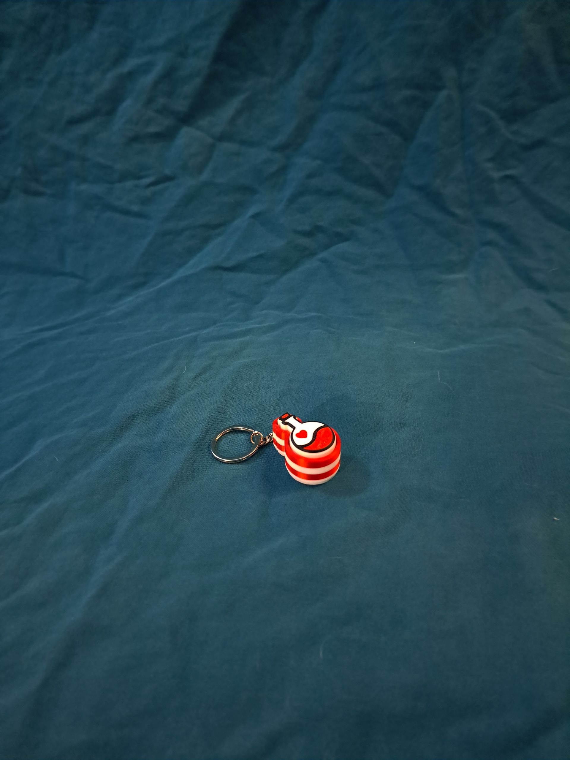 Red and white love potion clicker keychain.