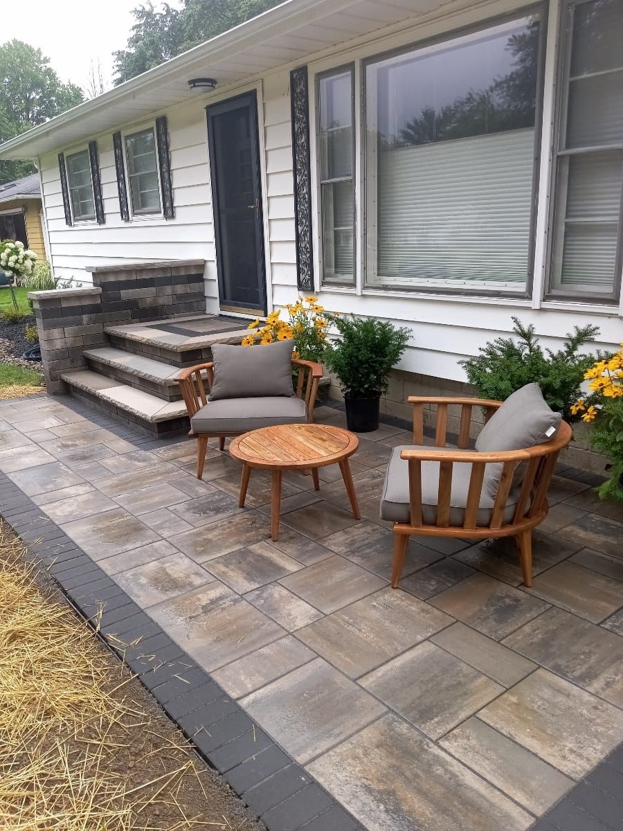 A home's patio with seating, stone steps, and potted plants.