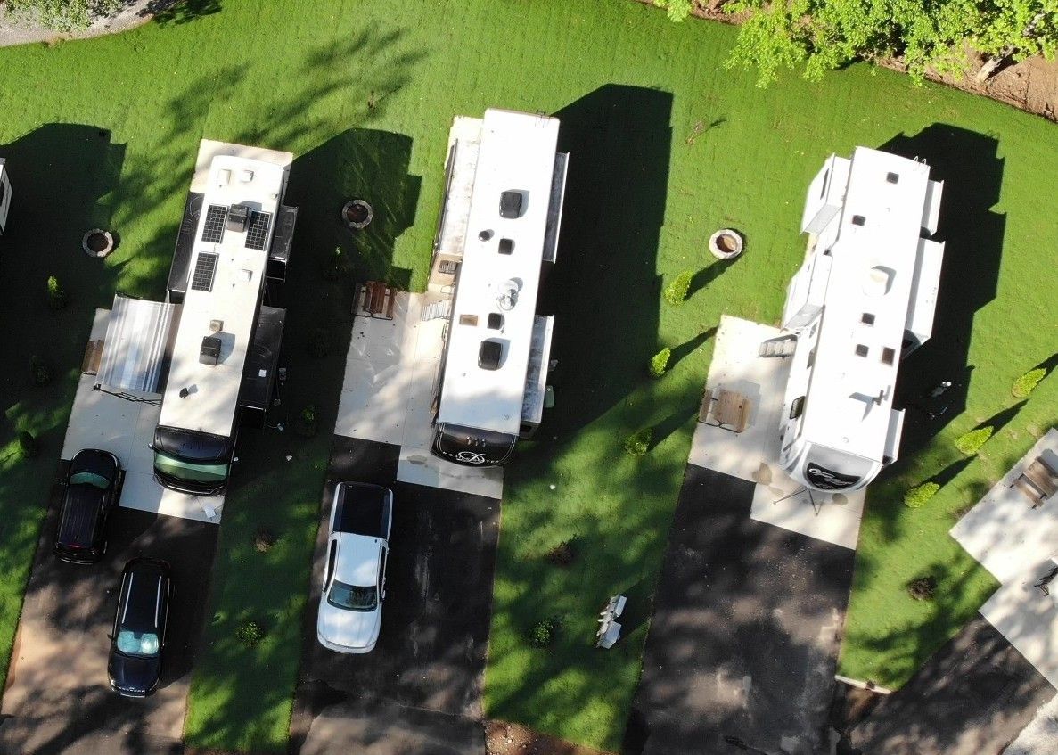 A row of rvs parked on the side of the road in a campground.