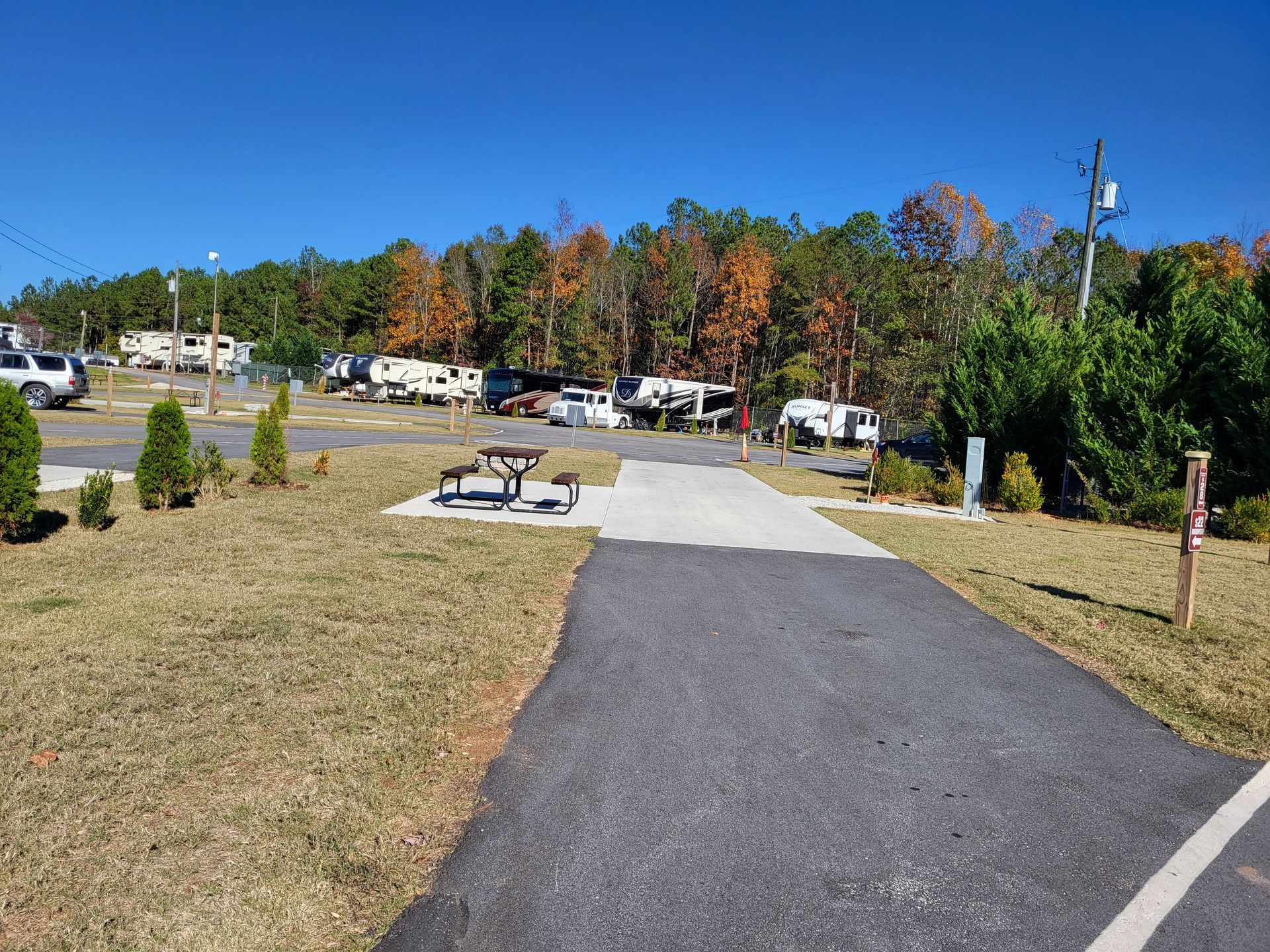A path leading to a campground with a picnic table in the middle.