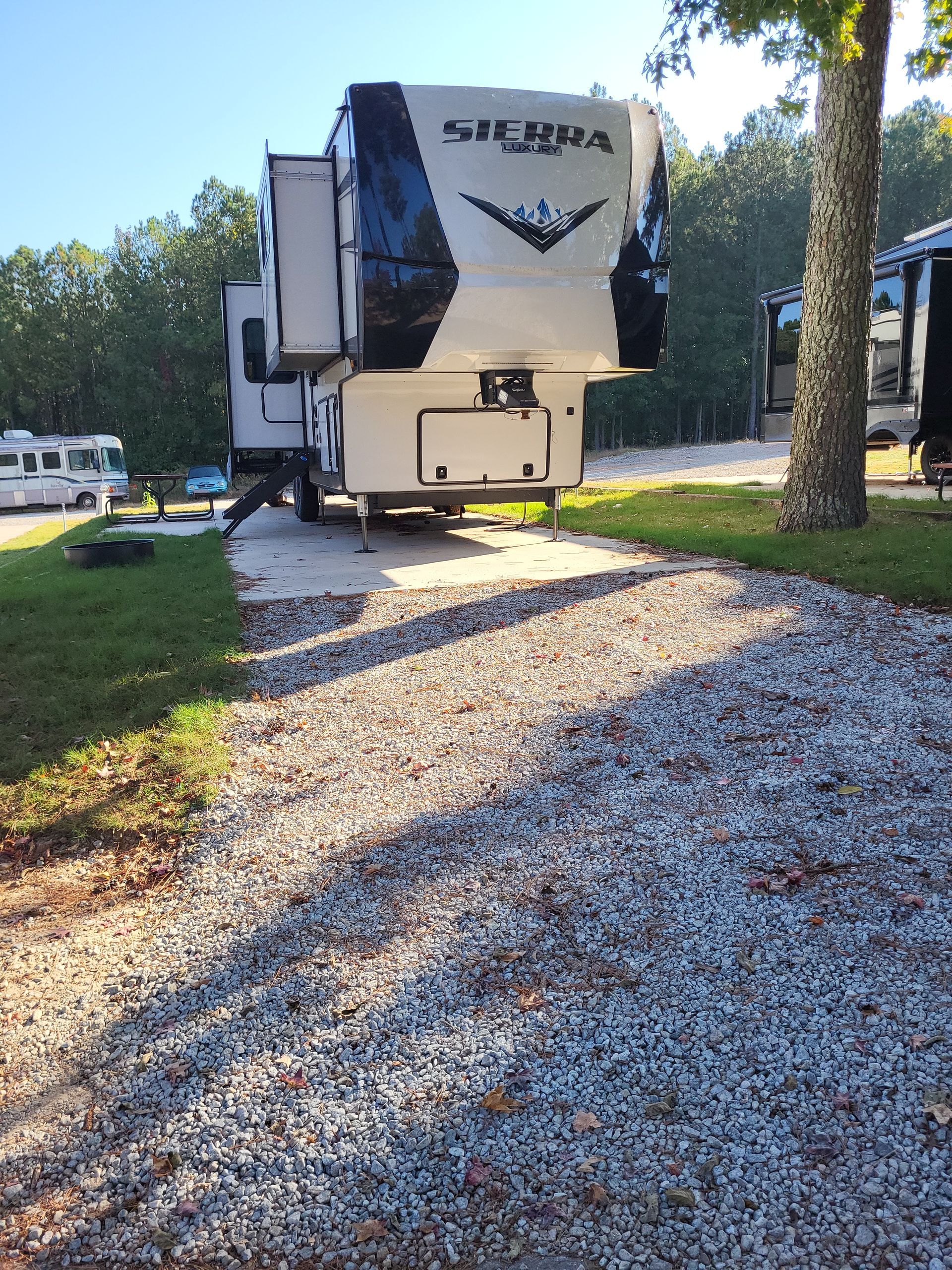 A sierra trailer is parked in a gravel lot