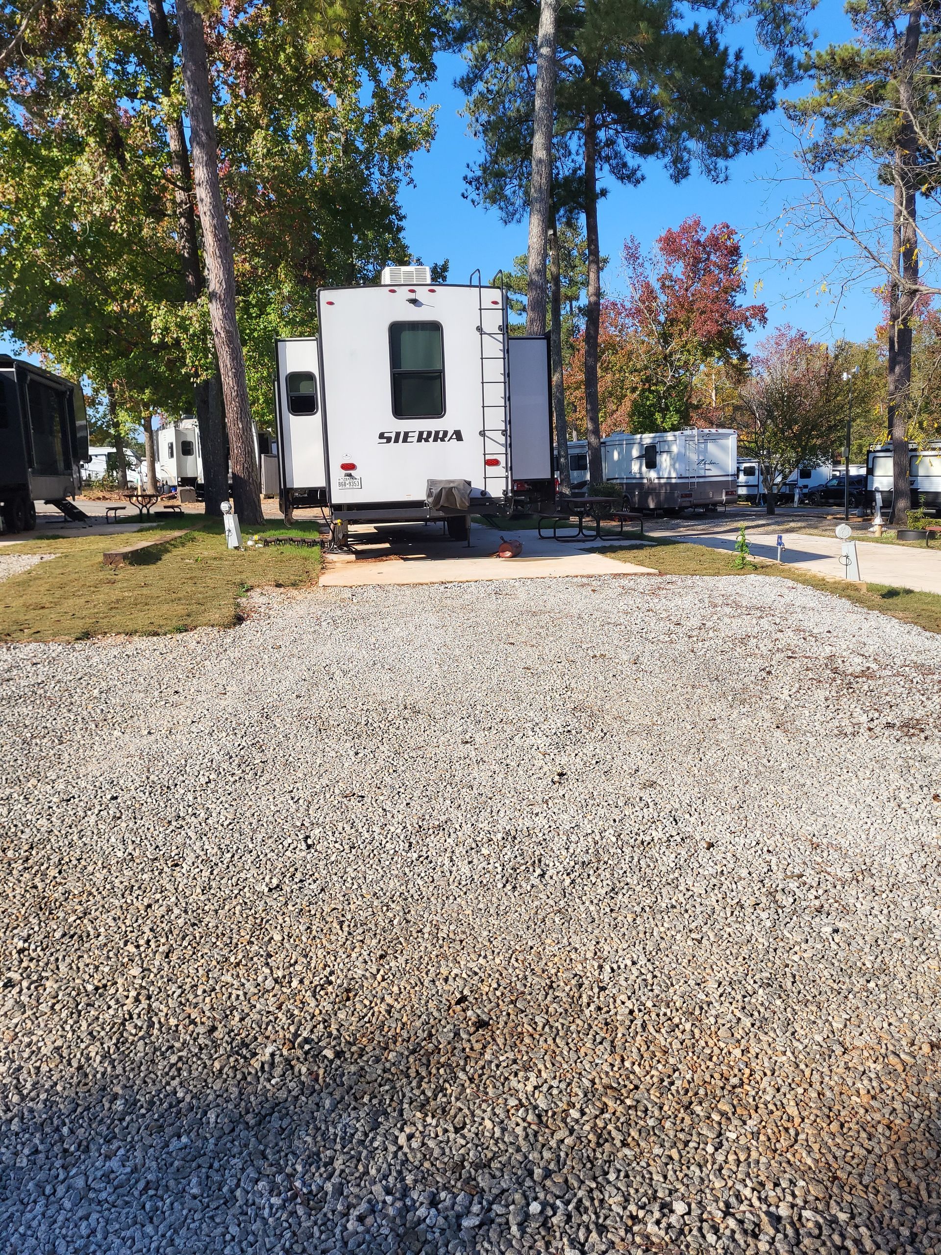 A white rv is parked in a gravel lot