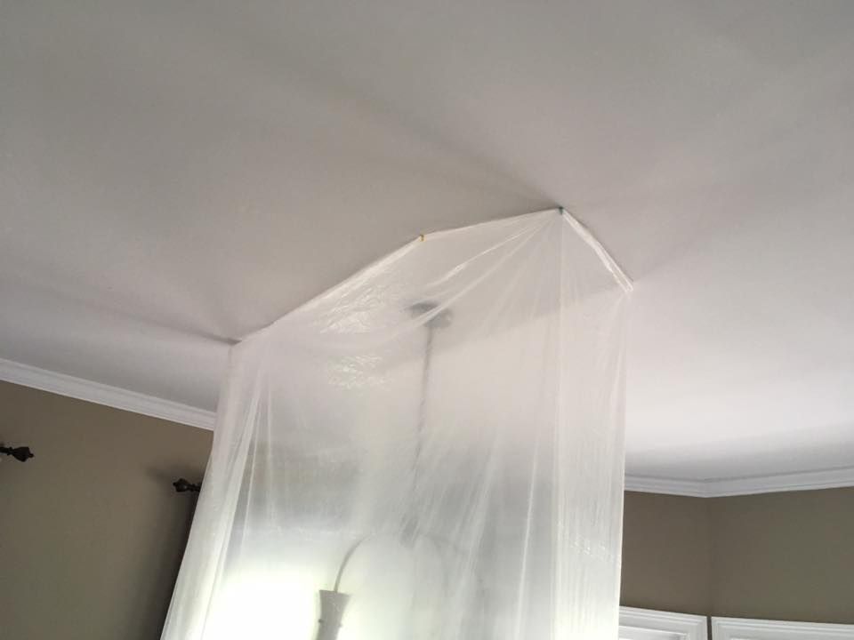 Plastic sheeting is hanging from the ceiling of a room.