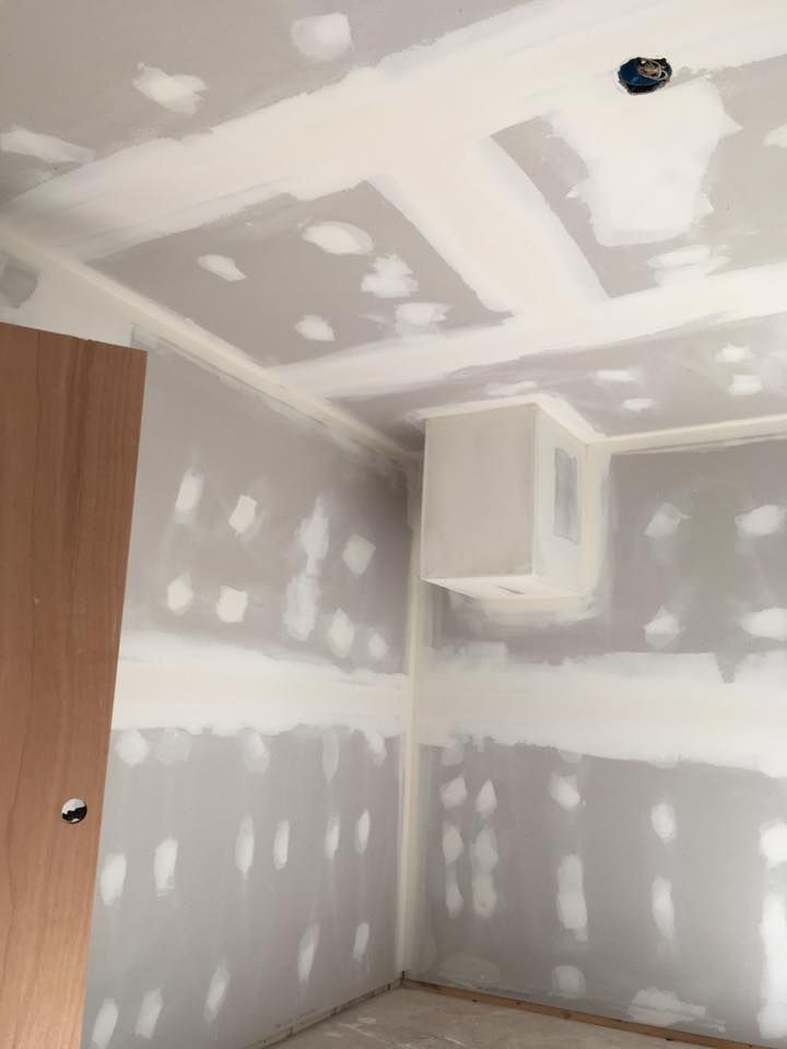 A room that is being remodeled with drywall on the walls and ceiling.