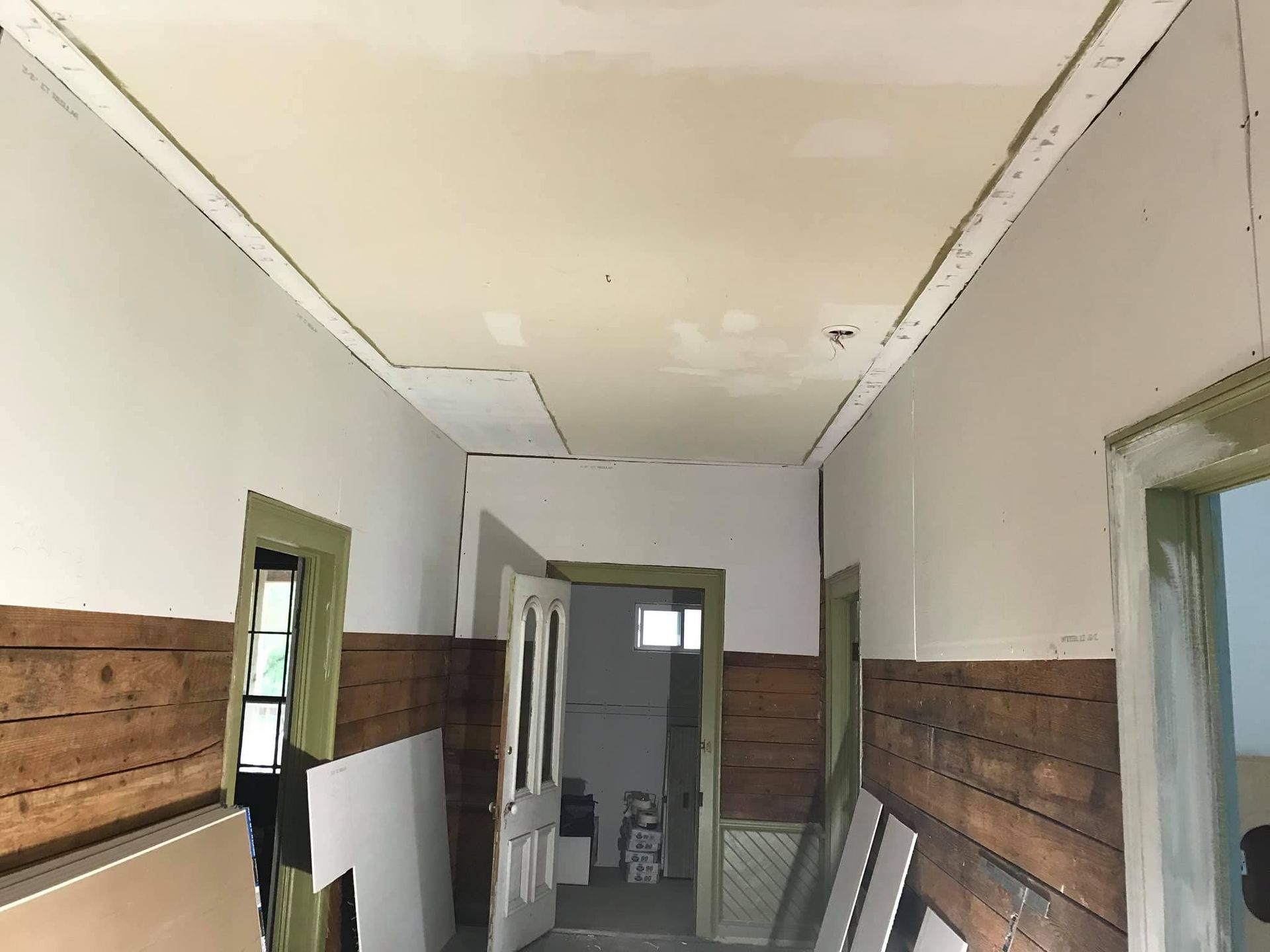 A hallway with wooden walls and a white ceiling