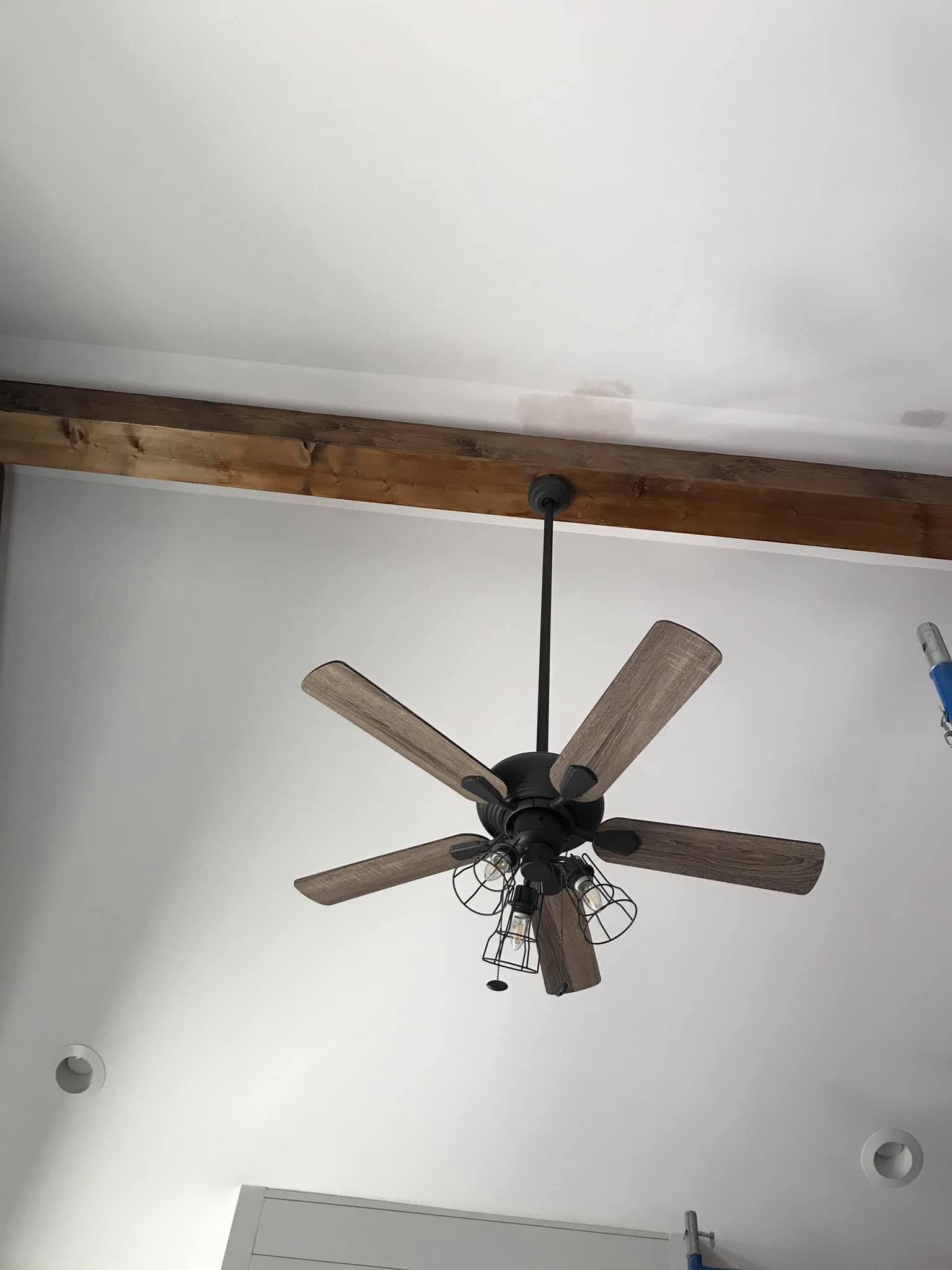 A ceiling fan is hanging from the ceiling of a room.
