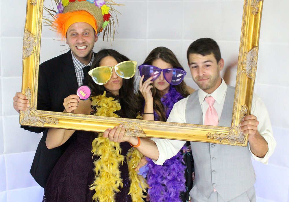 A group of people are posing for a picture while holding a picture frame.