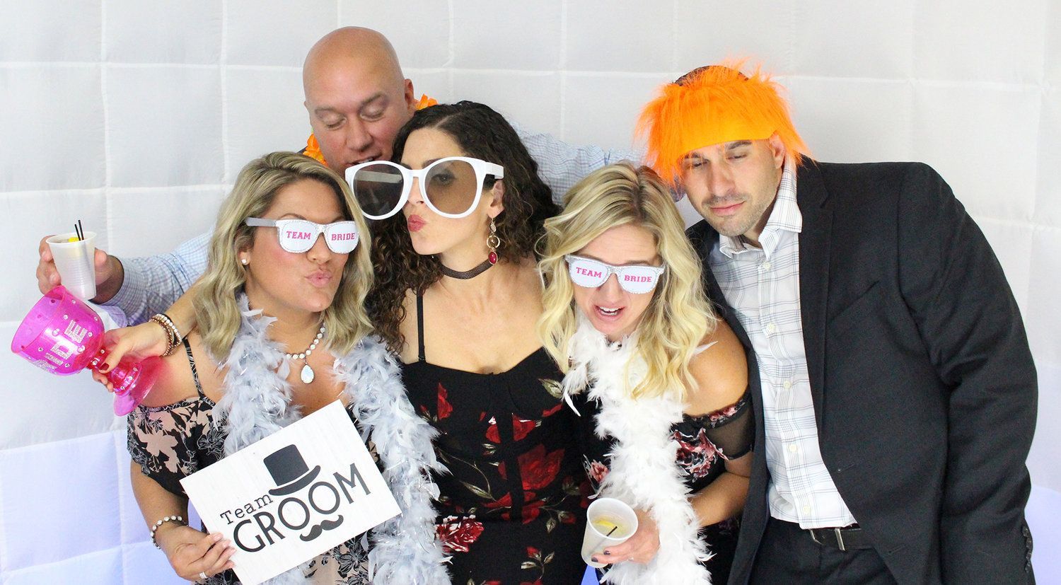 A group of people are posing for a picture while holding a picture frame.