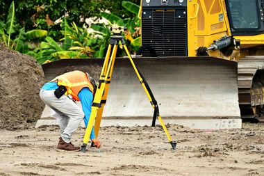 surveying in front of machinery