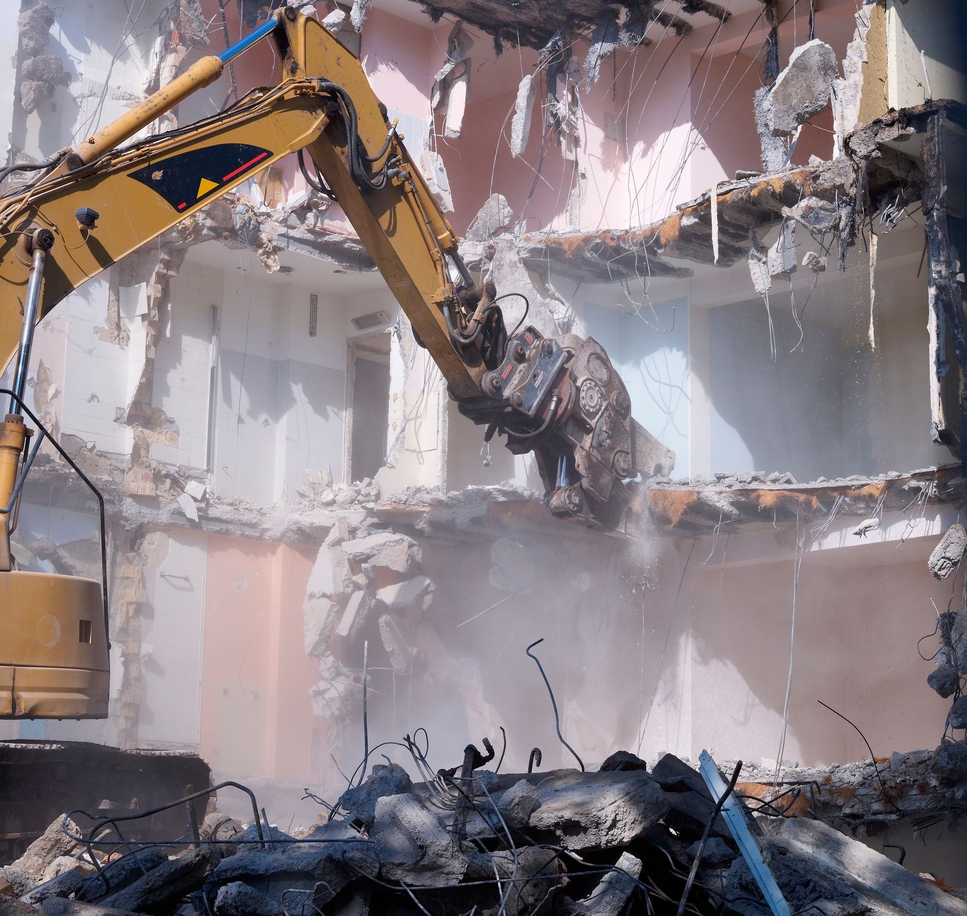 View of demolishing house with hydraulic cutter crane