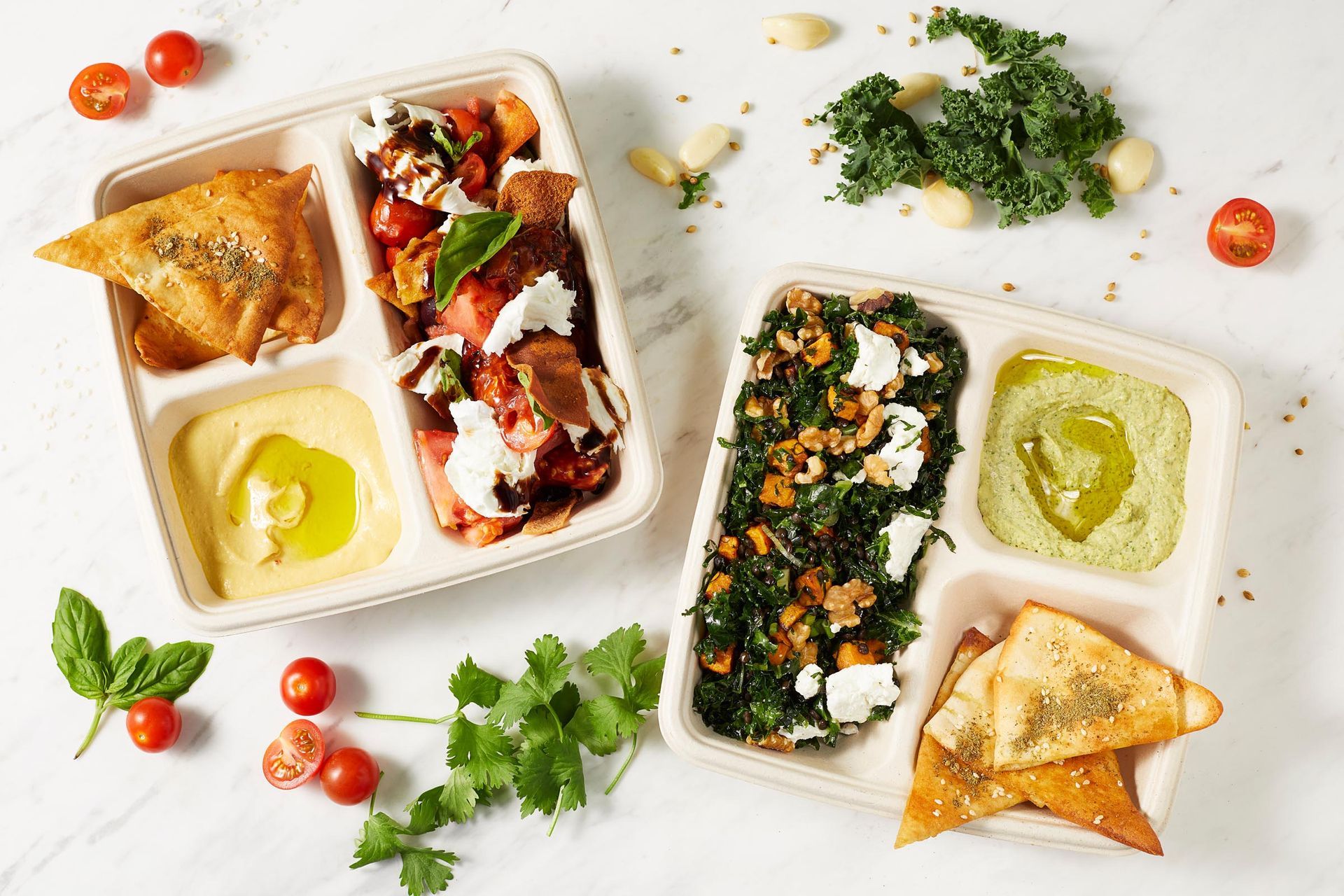 Two trays of food are sitting on a table.