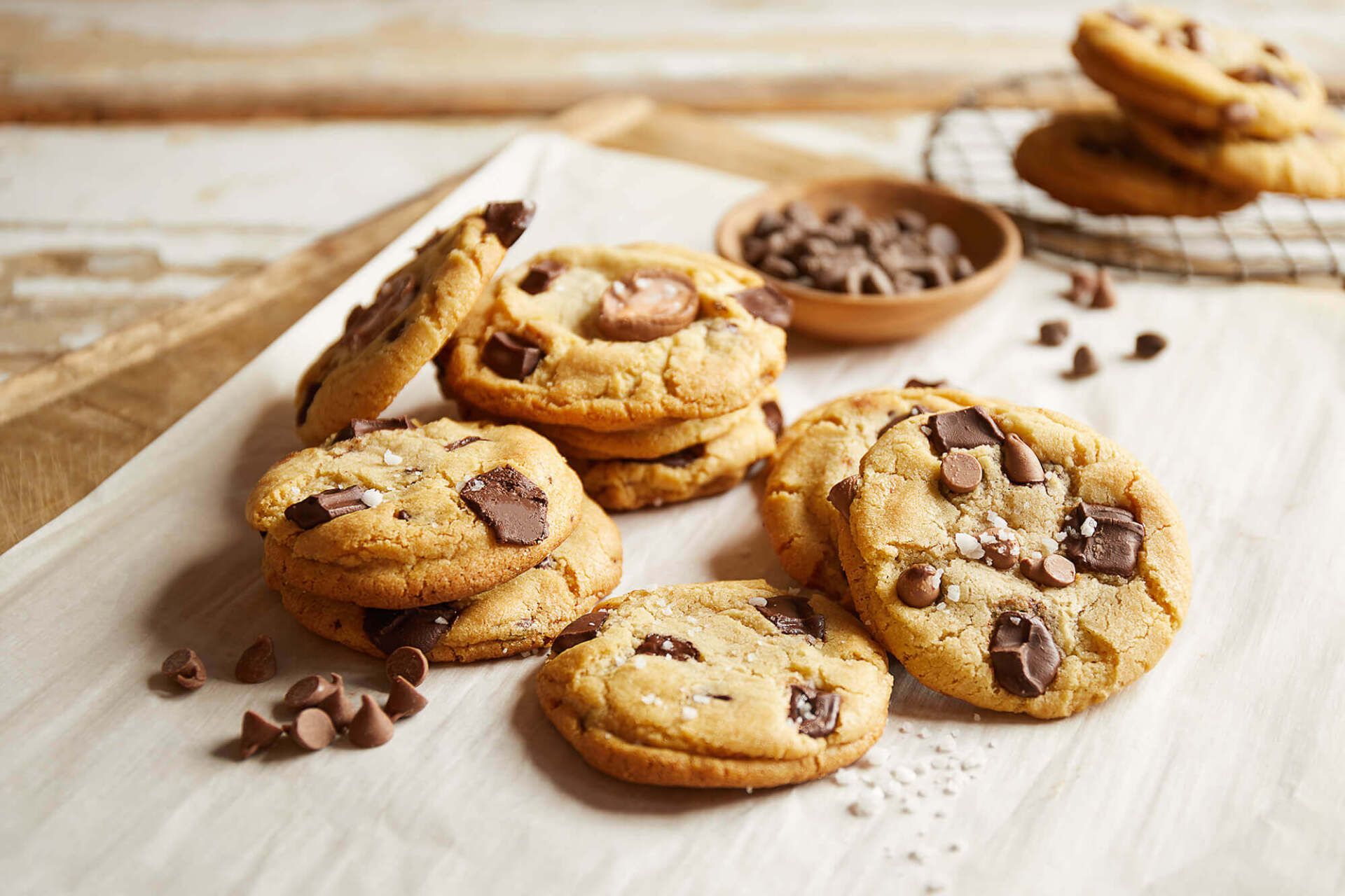 Chocolate chip cookies are stacked on top of each other on a table.