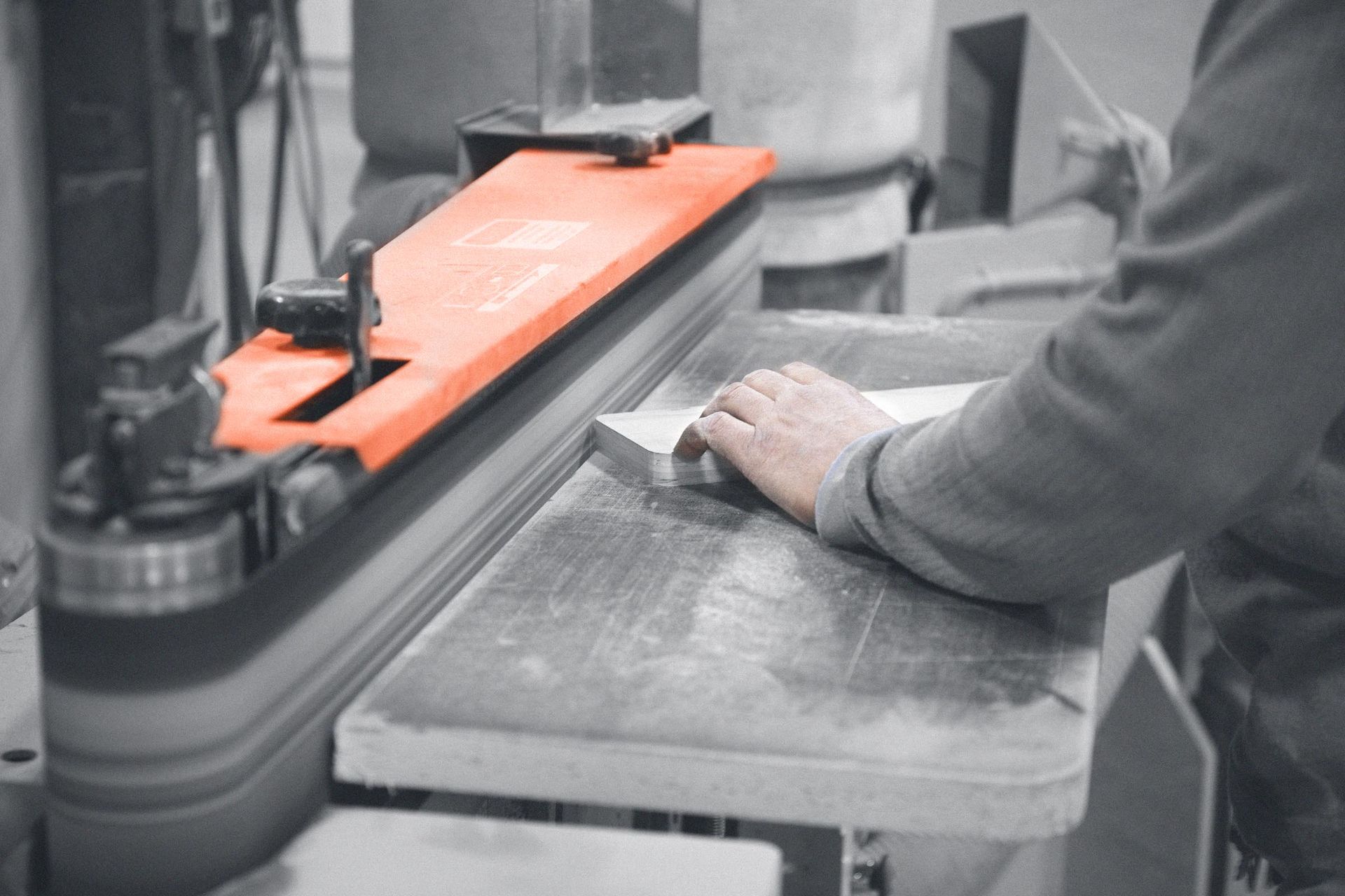 A person is using a machine to sand a piece of wood.