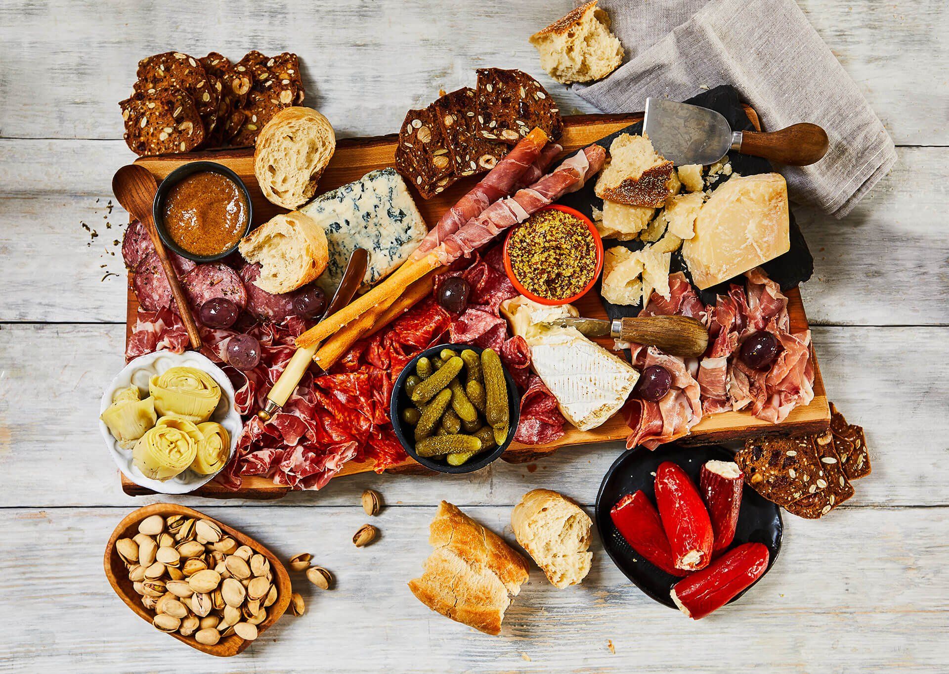 A wooden cutting board filled with lots of different types of food.